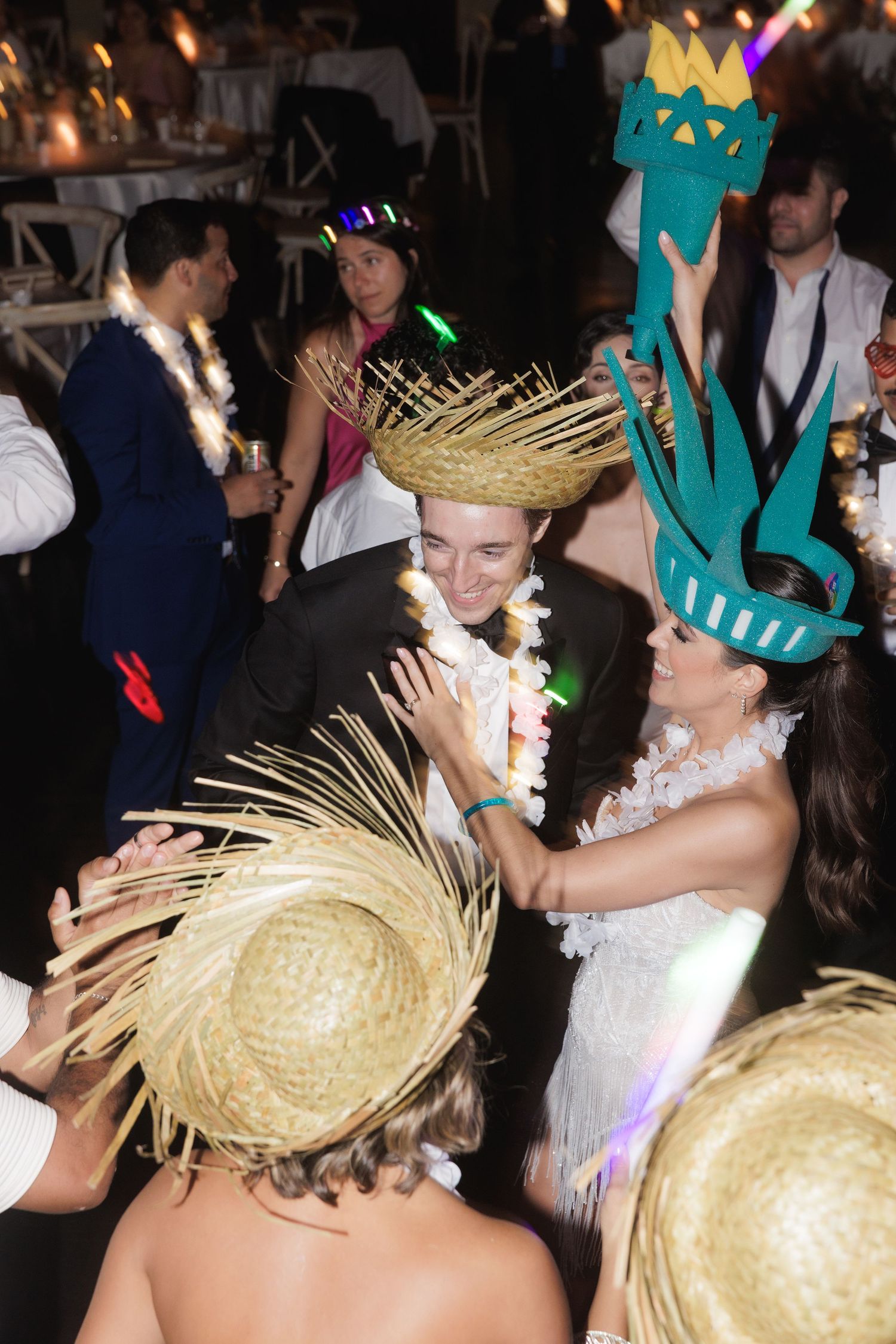 People dancing and celebrating at a party wearing festive metallic gold headpieces and crowns.