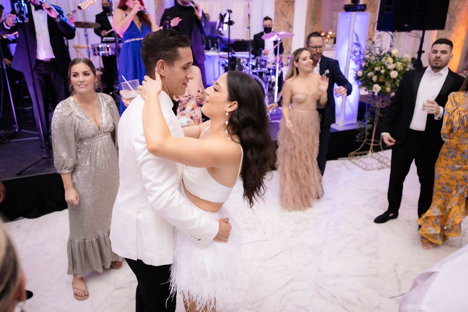 Wedding guests celebrate on a decorated dance floor during a lively reception.