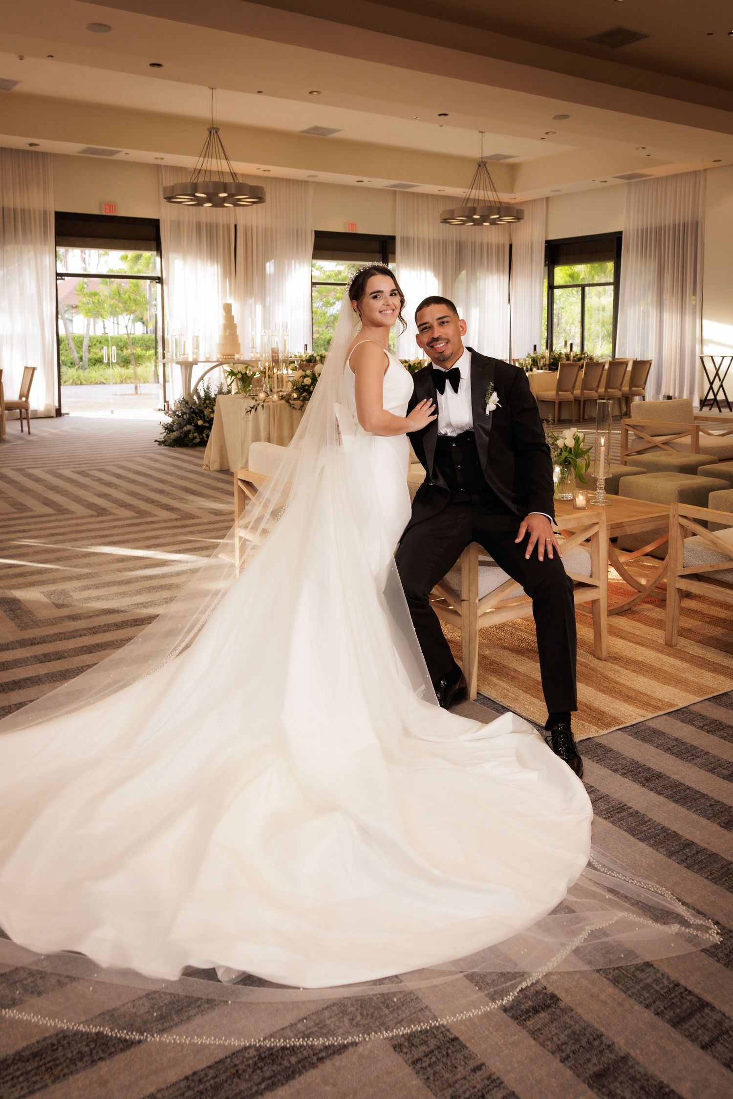 A wedding couple dances and twirls on a geometric patterned floor in an elegant indoor venue.