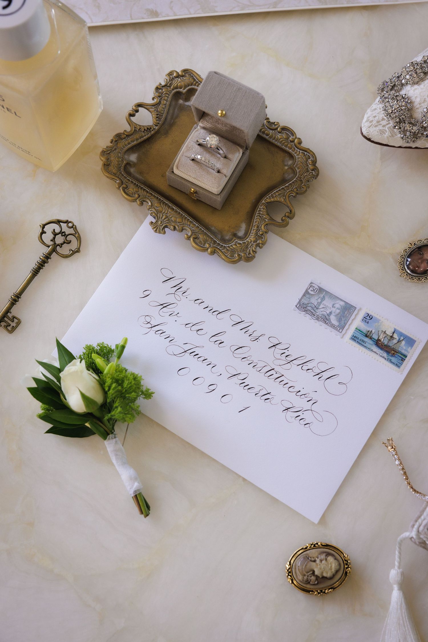 Vintage-styled place cards and decorative keys arranged on cream colored fabric.