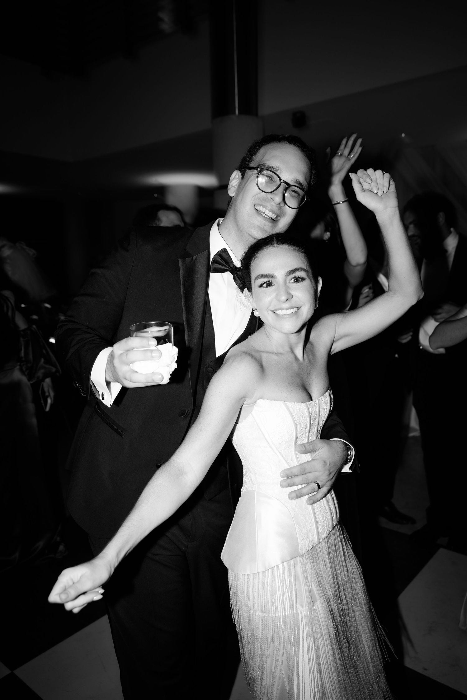Black and white photo of a joyful dance moment during an elegant wedding reception.