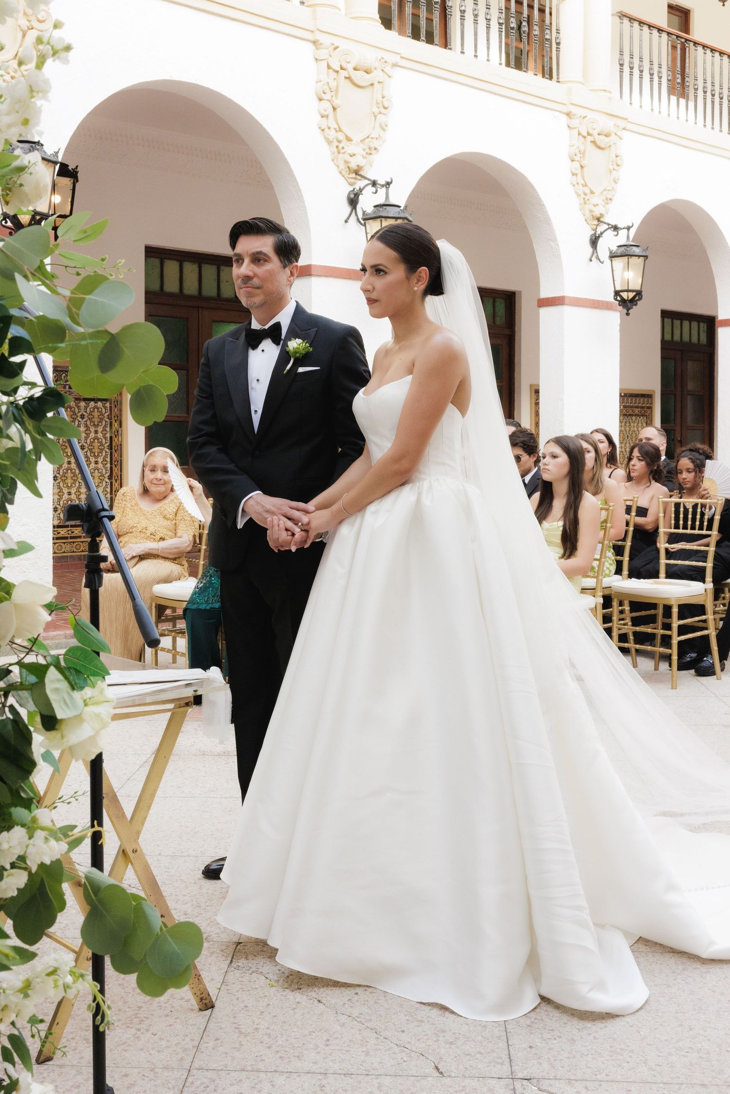 Wedding ceremony at Casa de España with elegant white columns and arches.