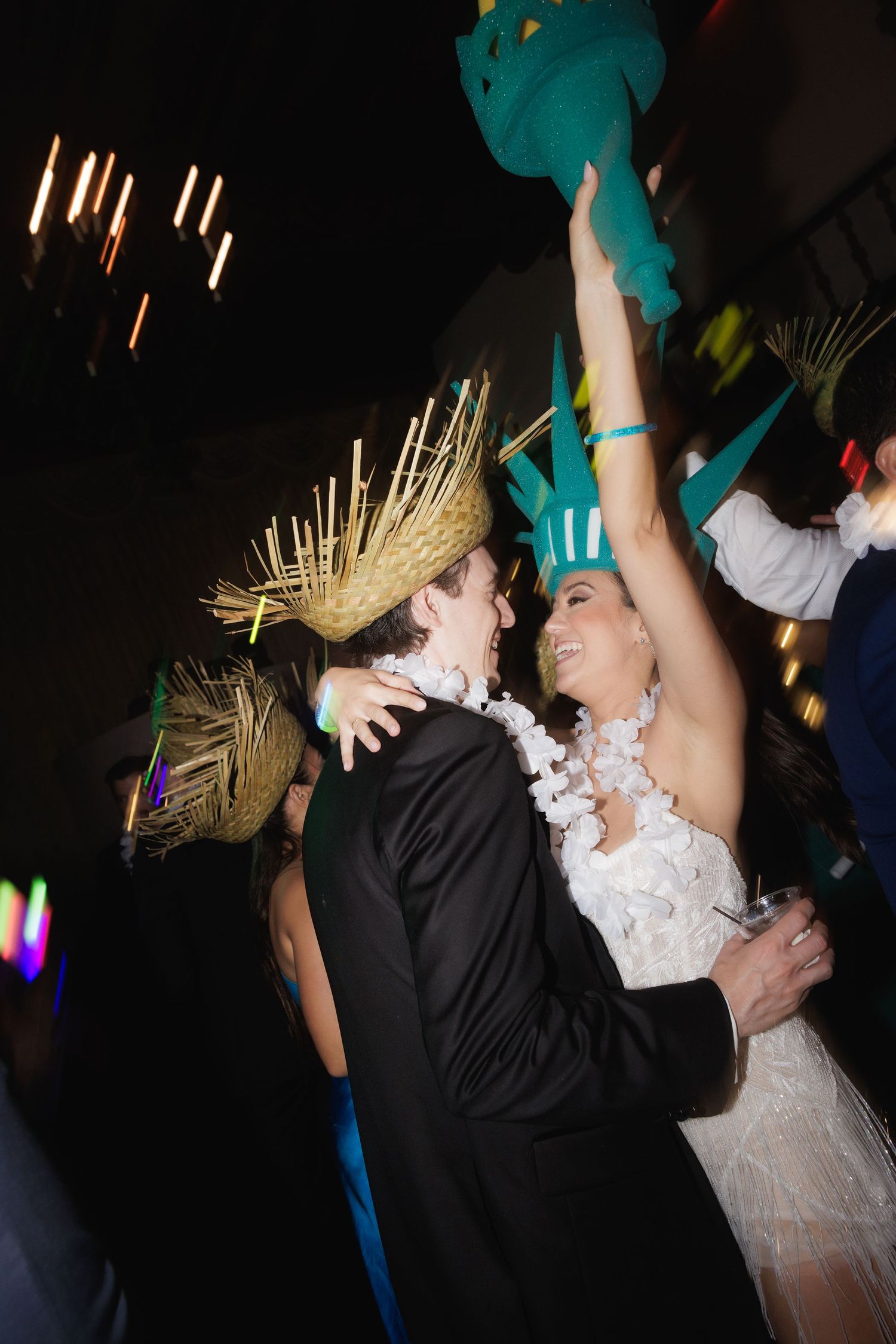 A couple in wedding attire dances and spins together on a darkened dance floor during their celebration.