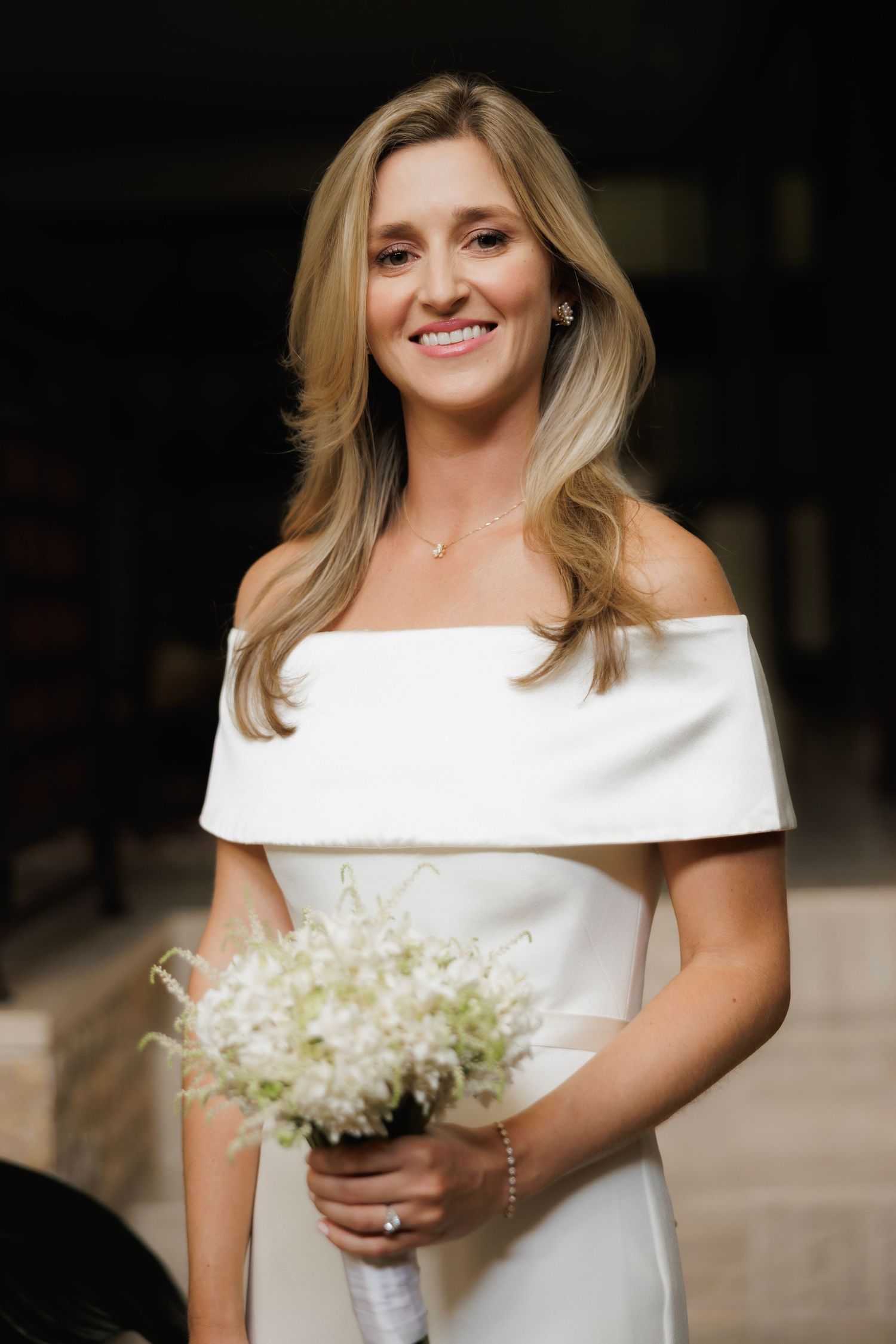 Portrait series showing a bride in an elegant white off-shoulder gown holding a delicate bouquet of white flowers.