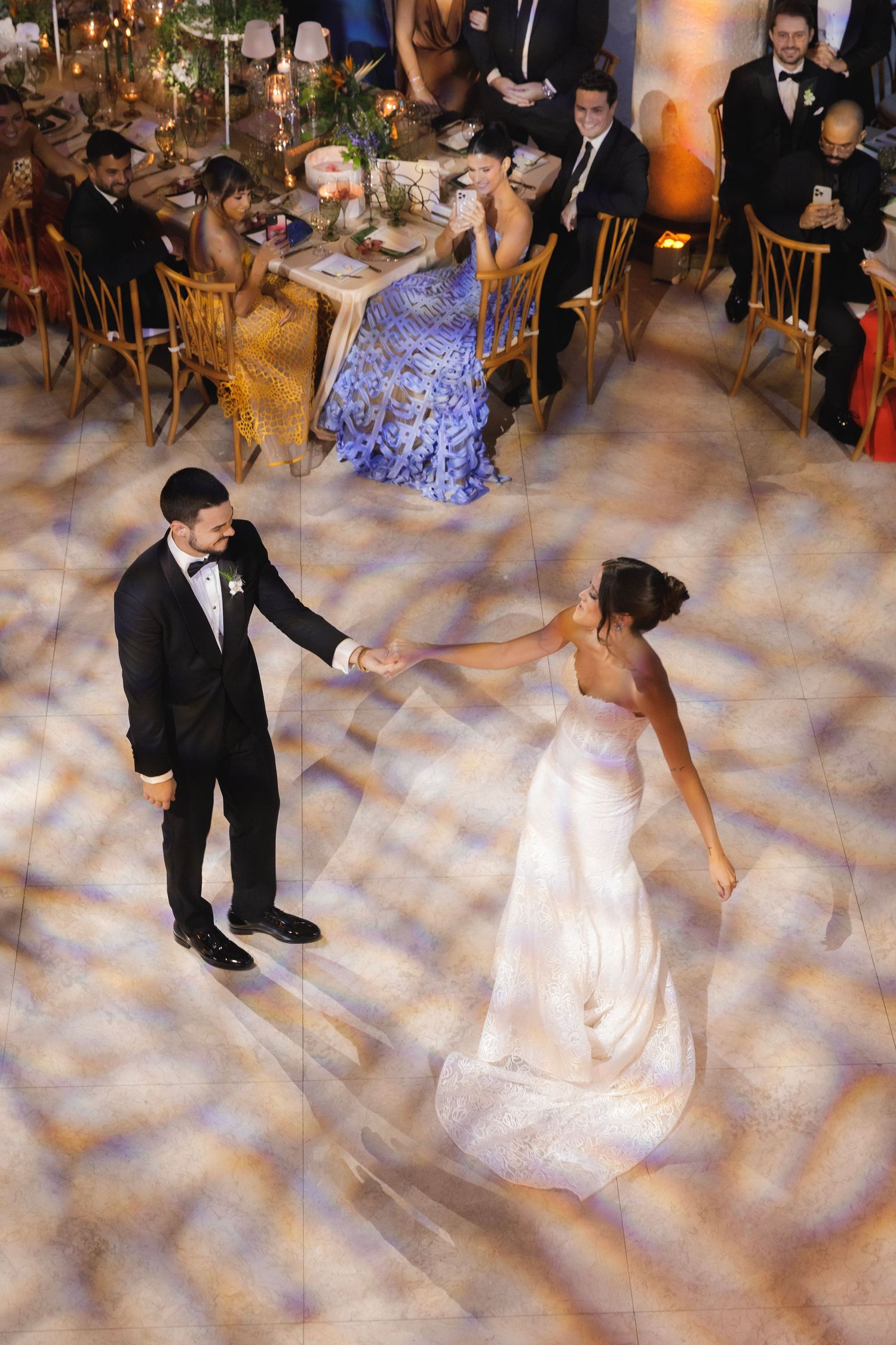 A couple dances gracefully across a misty dance floor during what appears to be their wedding celebration.