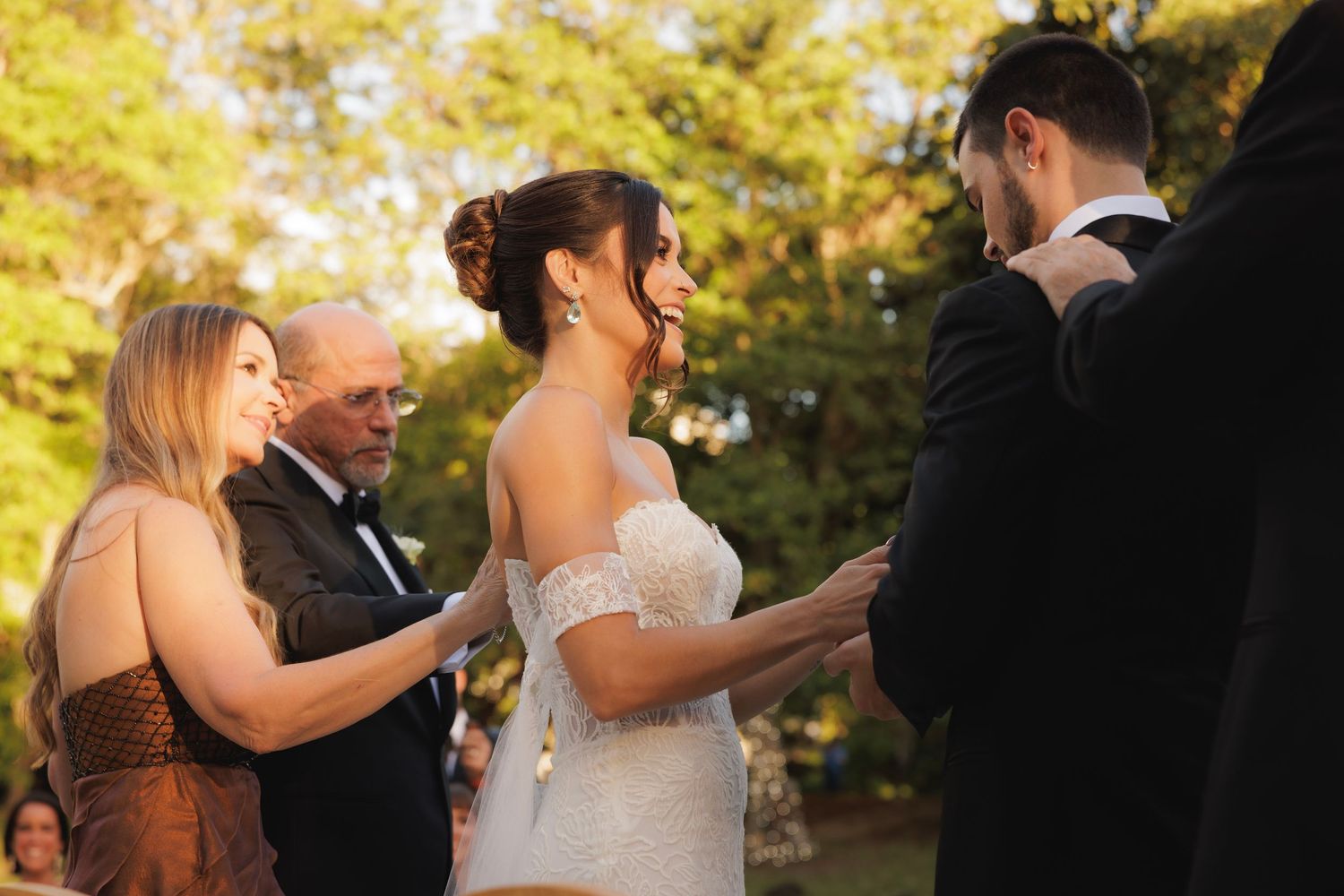 People dancing in lines during an outdoor wedding celebration with autumn trees in background.
