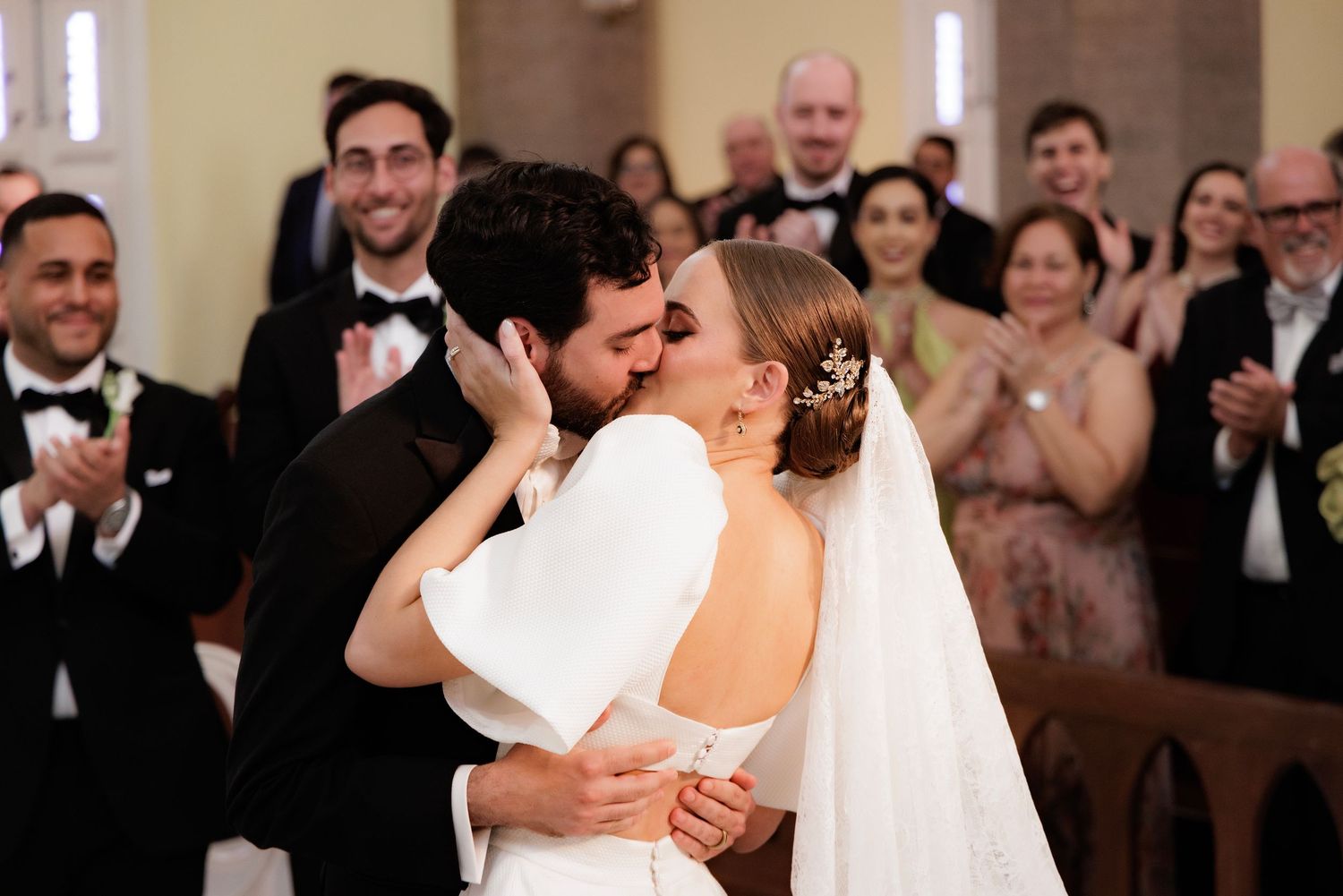 Newlywed couple shares a romantic dance together at their wedding reception while guests watch and celebrate.