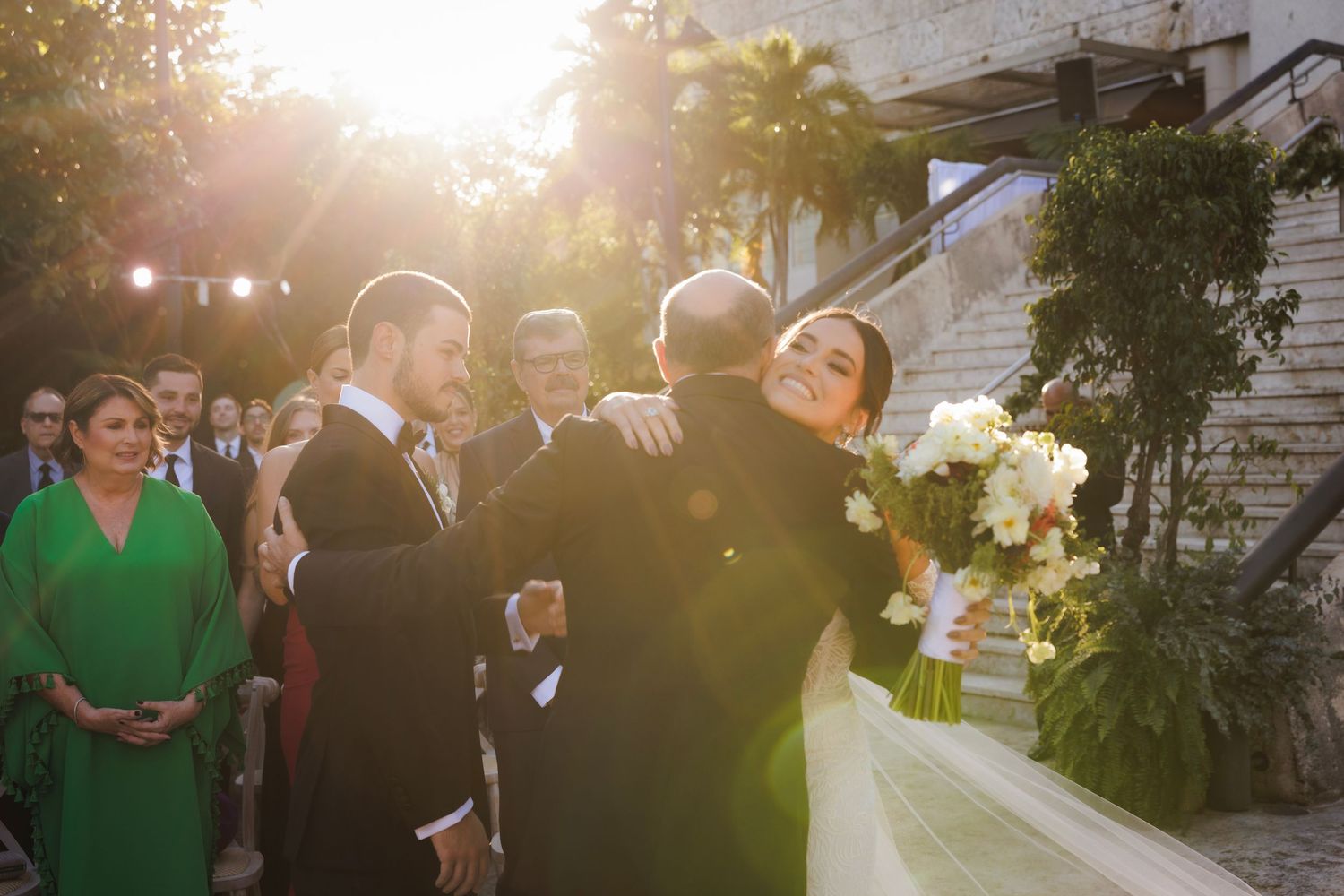 A gathering at a sunset wedding ceremony captured during golden hour with guests enjoying the outdoor celebration.