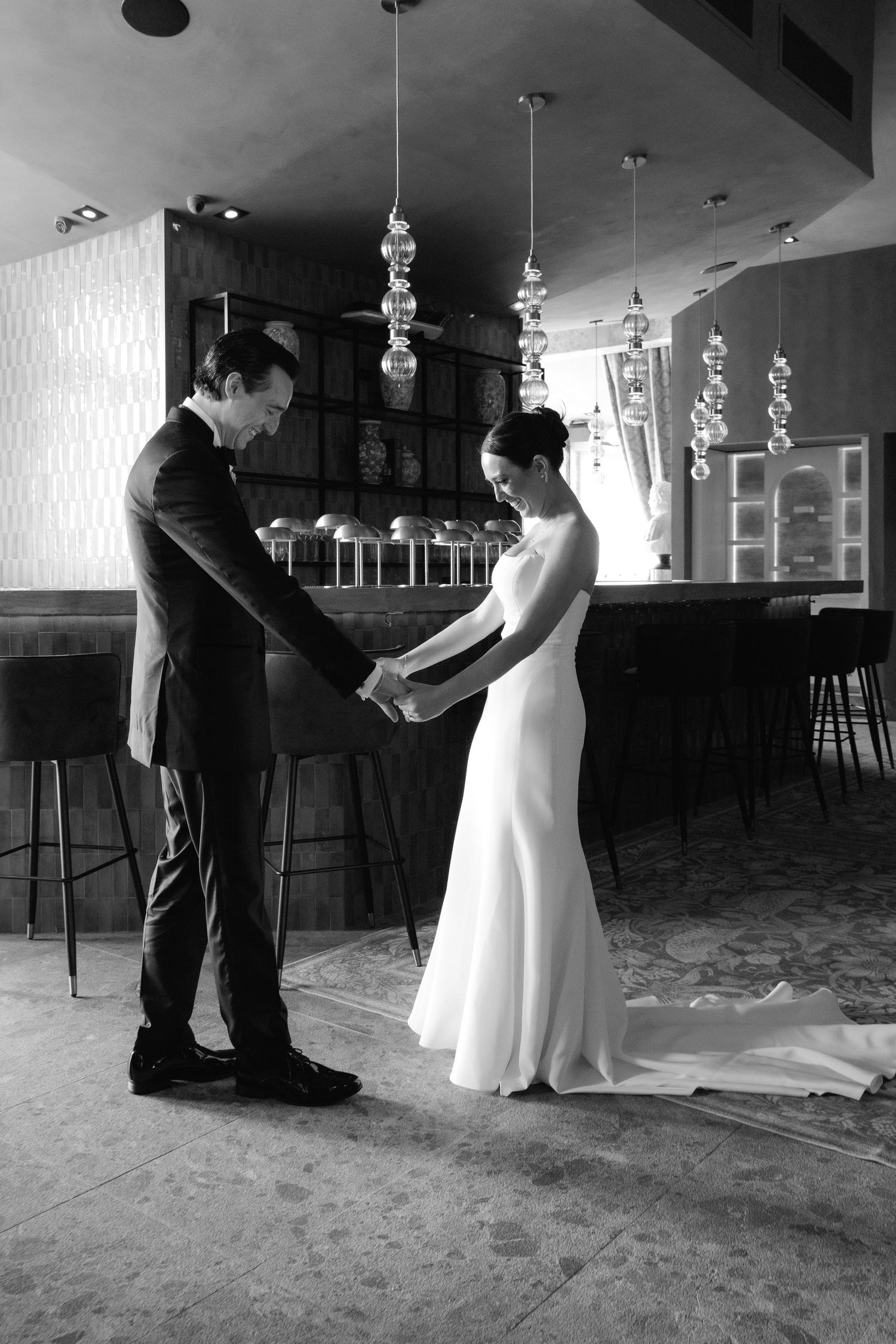 Black and white dance sequence between two people in formal attire in an elegant indoor venue.