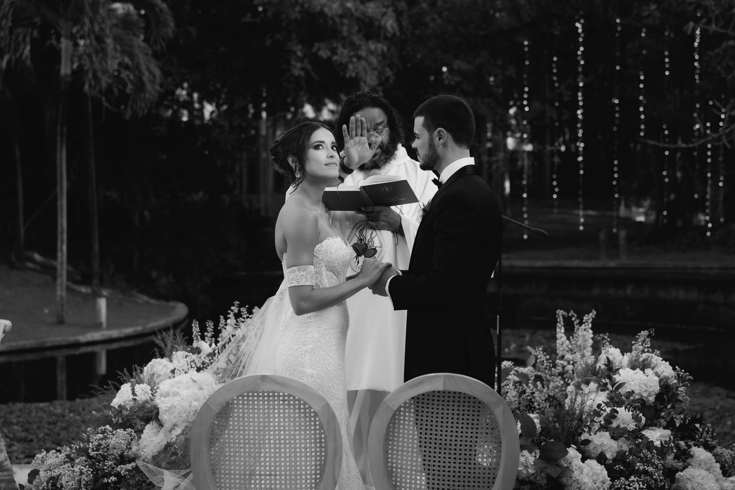 Black and white wedding photo showing a romantic moment during an evening outdoor reception.