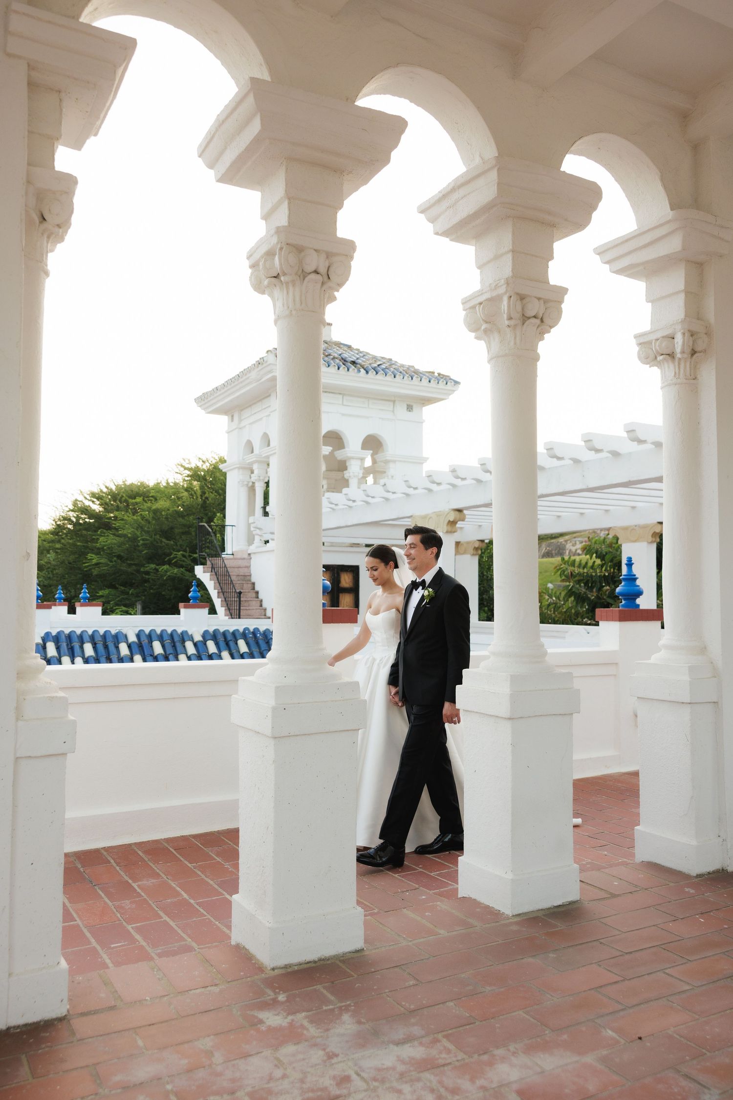 White columned architecture creates a dramatic backdrop for a wedding ceremony.