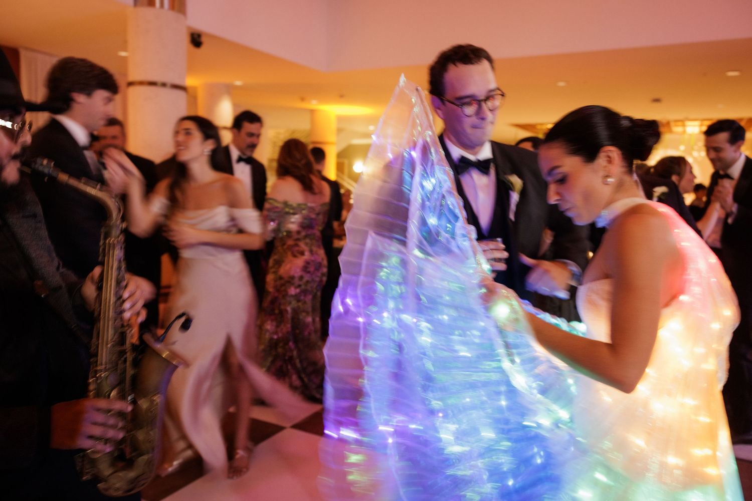 Wedding celebration featuring dancers with glowing LED costumes creating magical light effects on the dance floor.