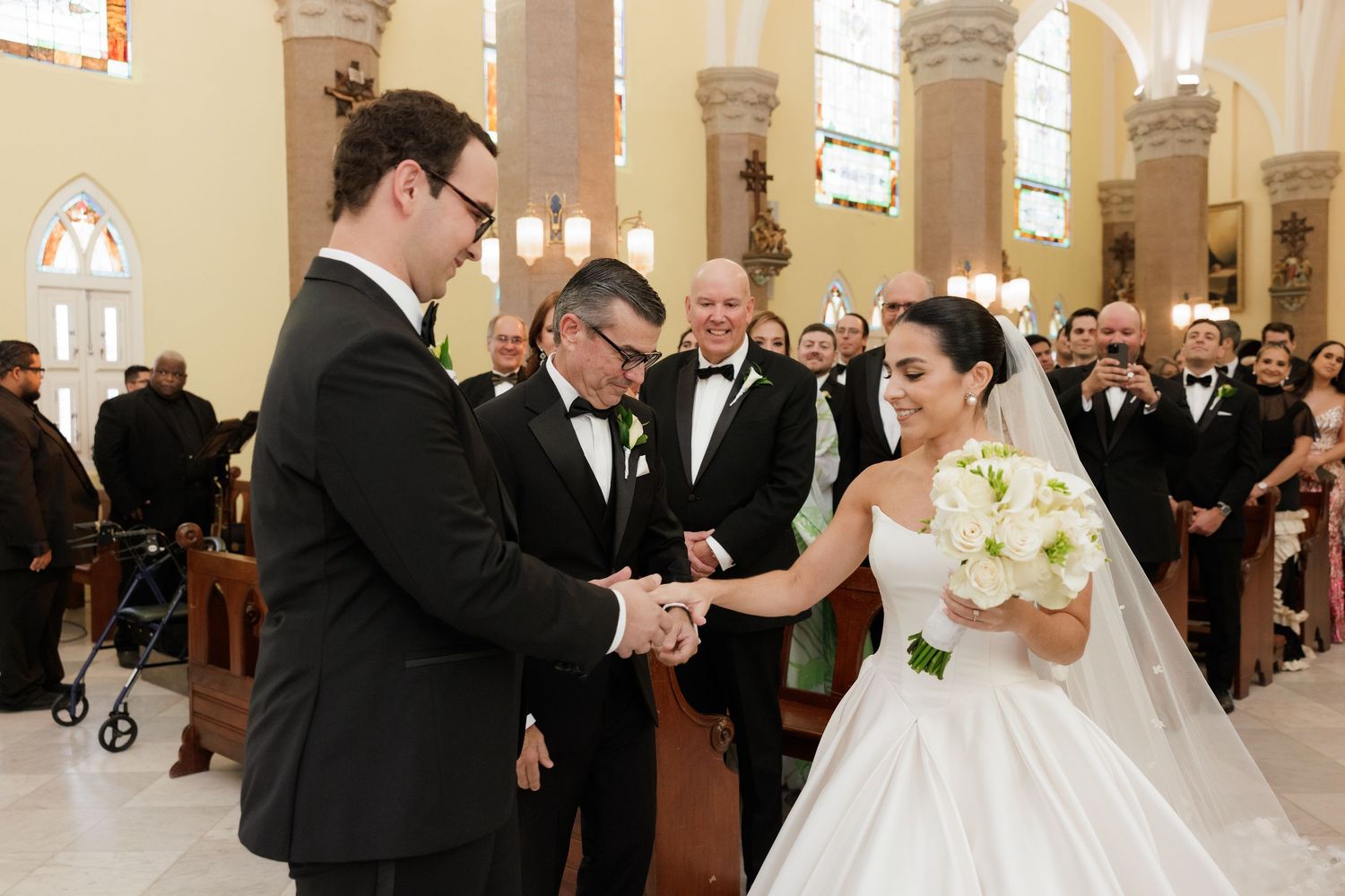 Wedding celebration inside an elegant church with guests lining the pews.