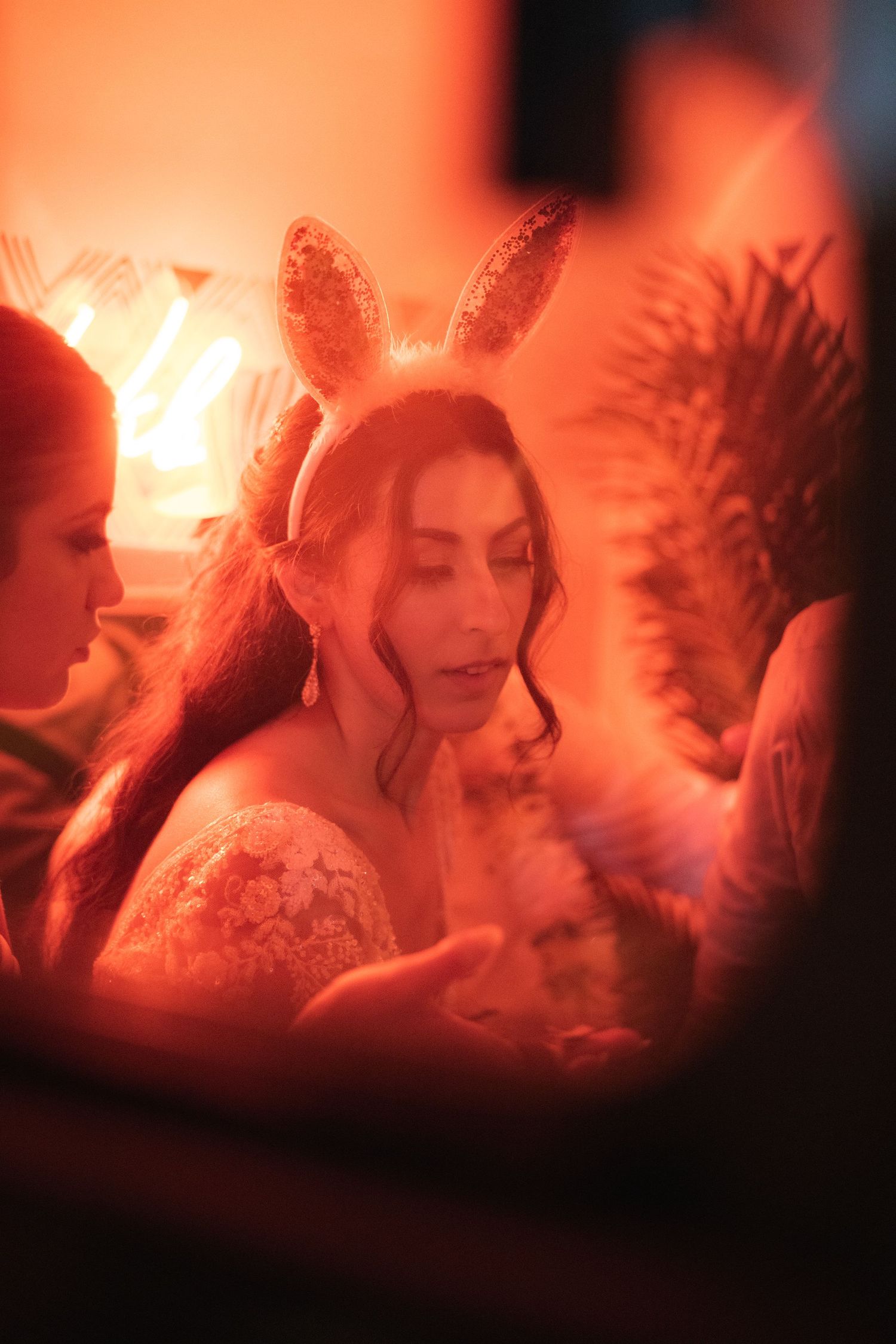 A series of romantic wedding photos in soft red lighting with ethereal glow and movement.