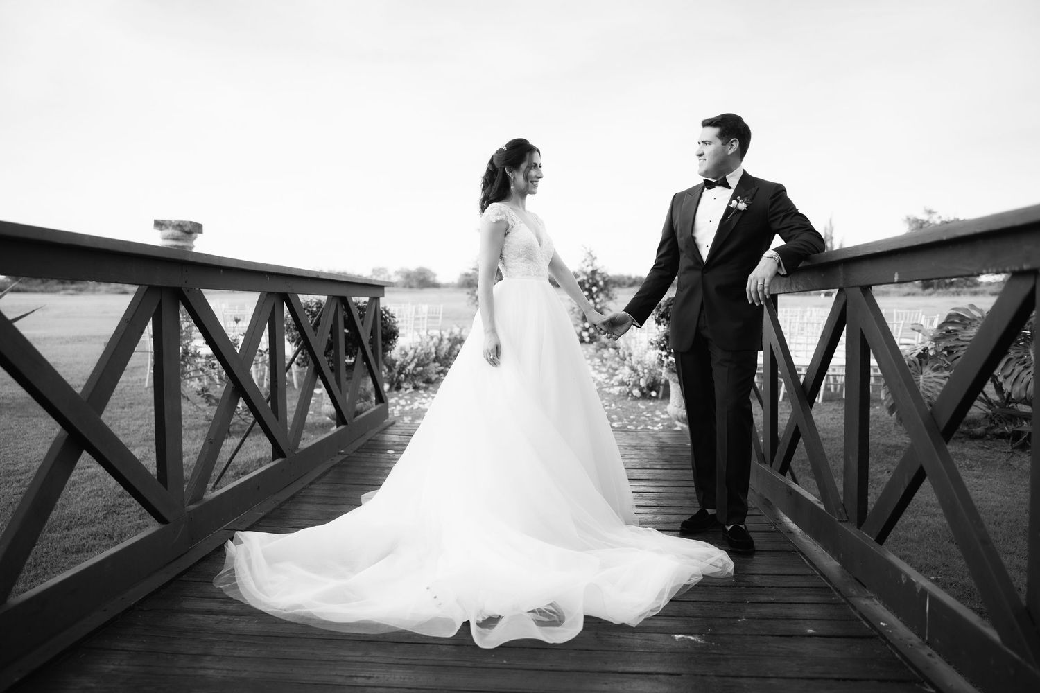 A romantic wedding couple portrait series on a wooden dock with dramatic lighting.
