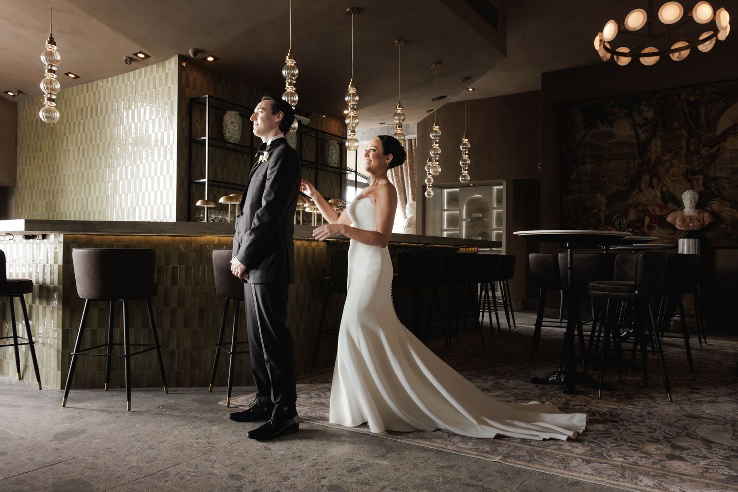 A first dance sequence collage showing five moments of a wedding couple twirling in an elegant venue with Edison bulbs.