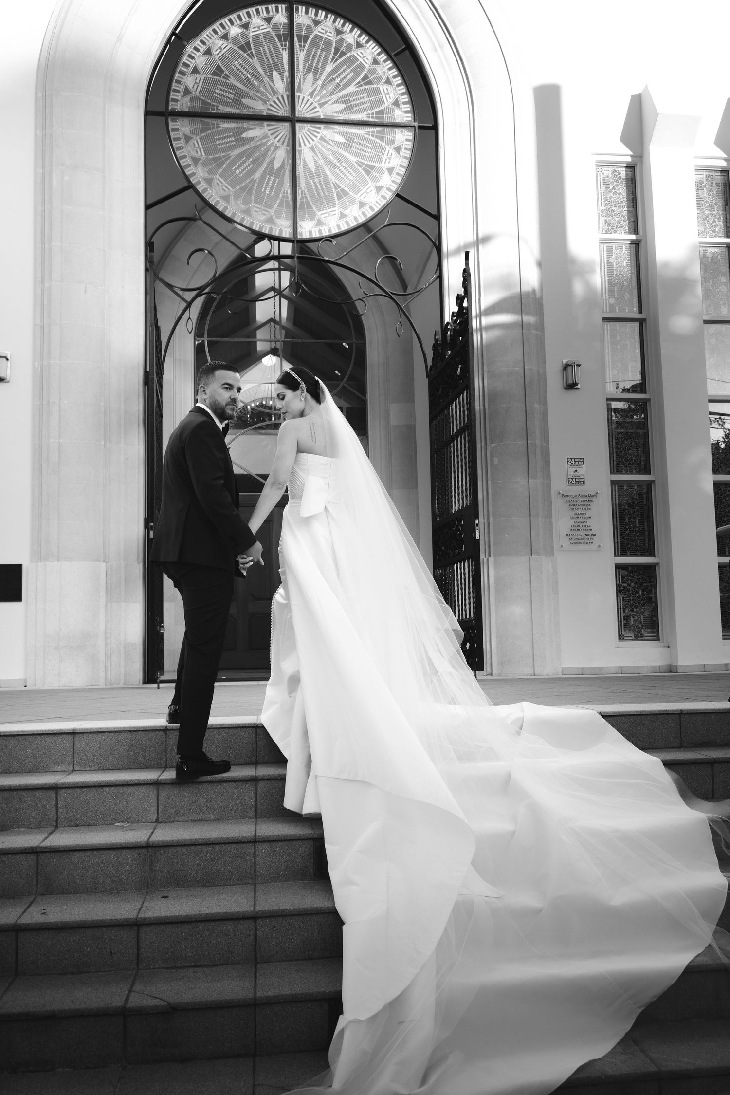 Black and white wedding photos with dramatic flowing veil against arched doorway.
