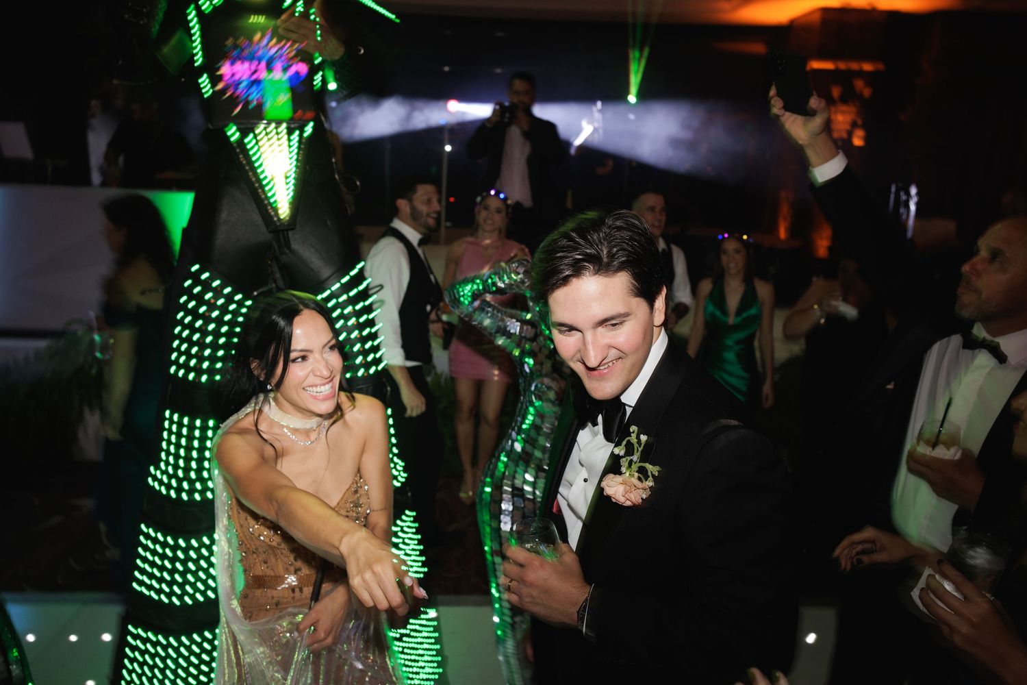 Green LED lights create a futuristic ambiance at a nighttime party event.