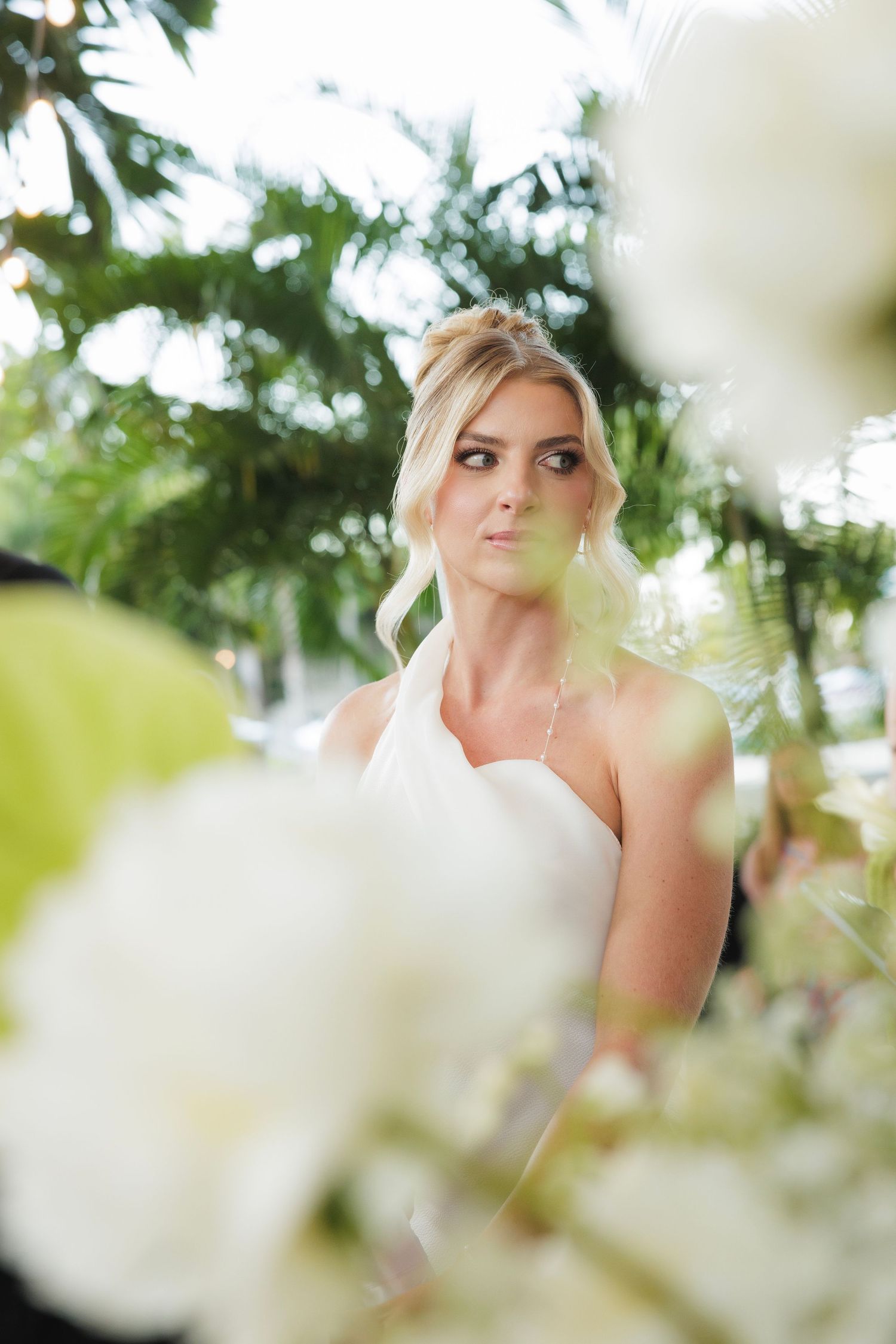 White spring blossoms frame and soften a romantic portrait composition in soft natural light.