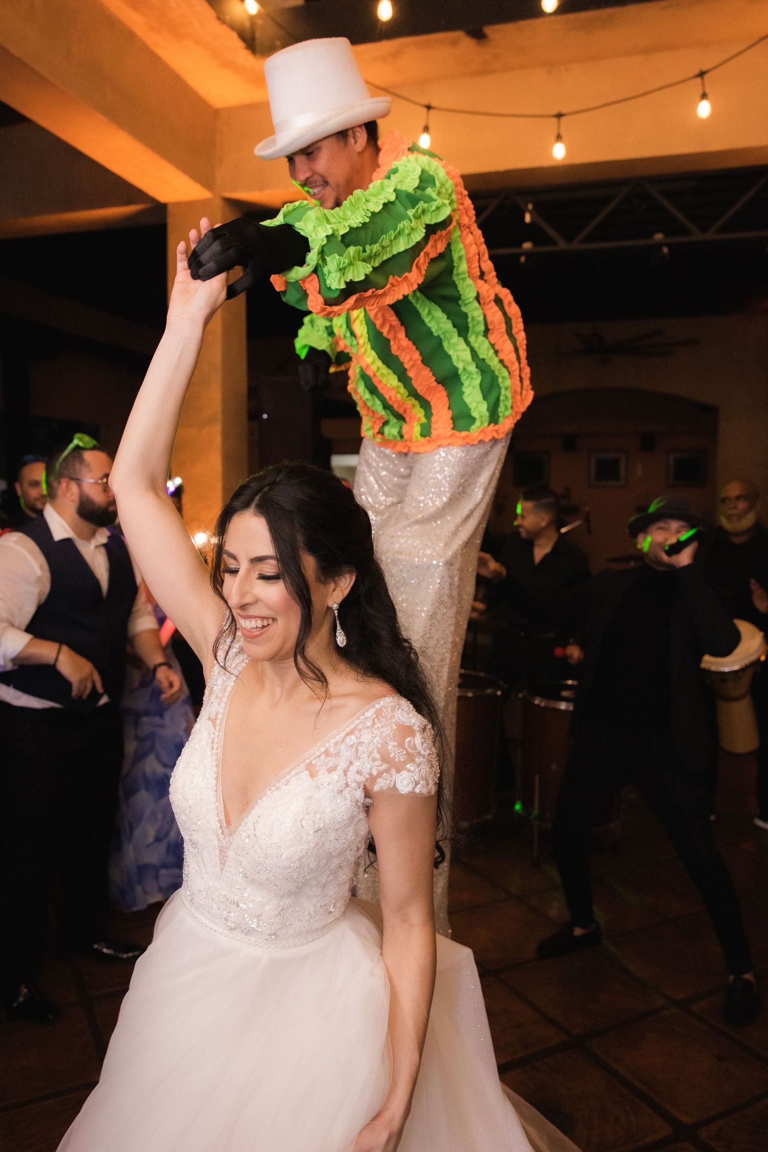 Wedding couple dancing at a reception venue decorated with string lights and festive decorations.