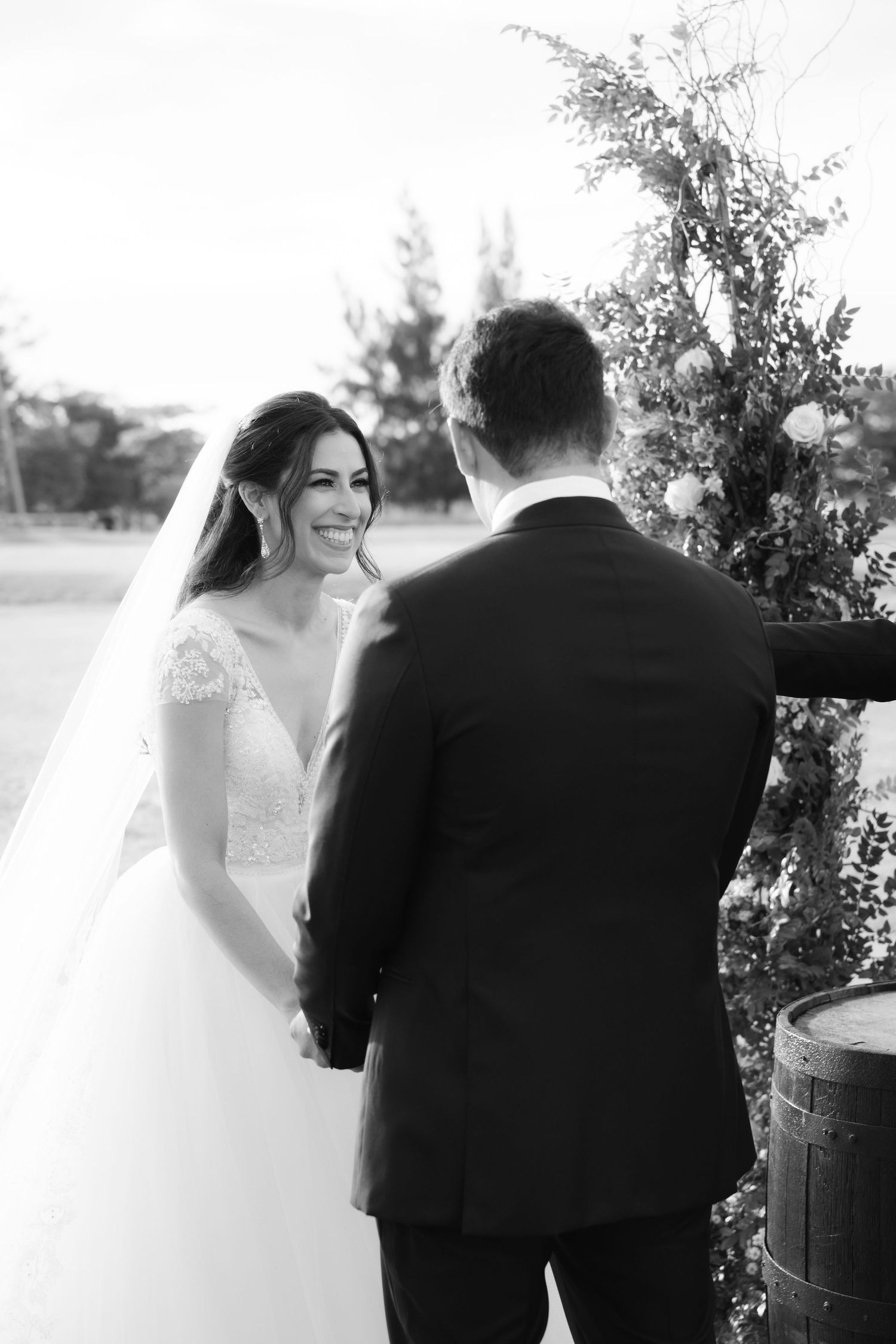 Black and white wedding photos show romantic moments between a couple sharing intimate glances outdoors.