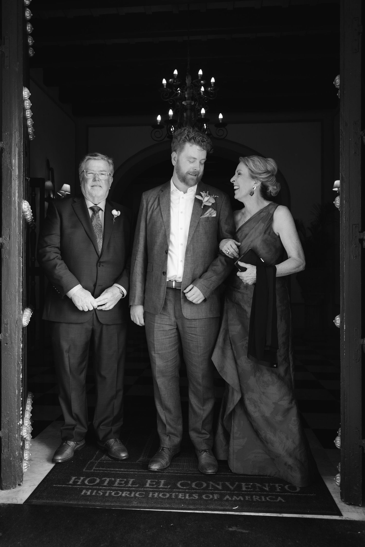 Wedding guests share a candid moment in black and white at Hotel El Convento.
