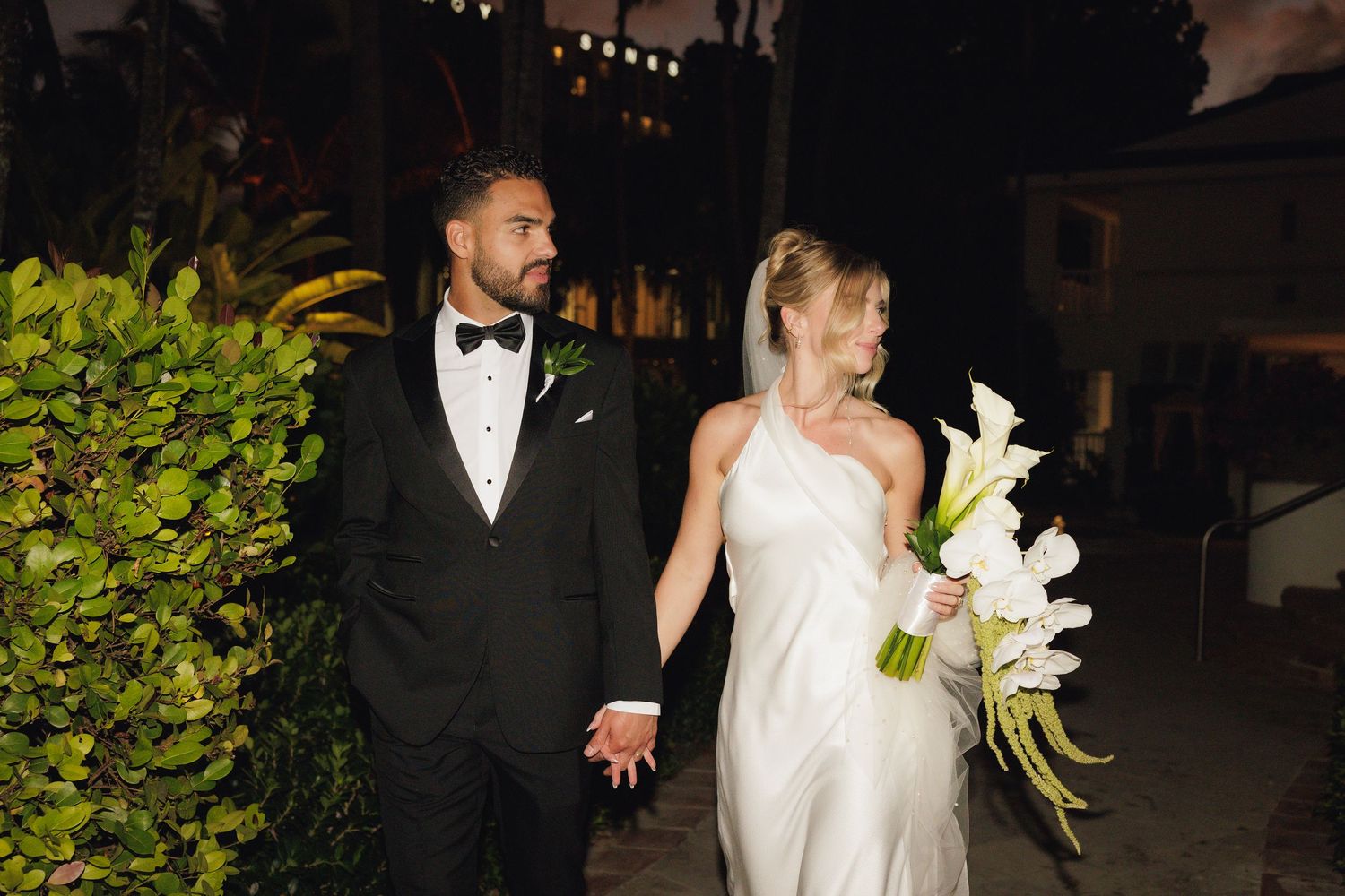 A series of wedding photos showing a bride and groom in formal attire walking together at night with elegant lighting.