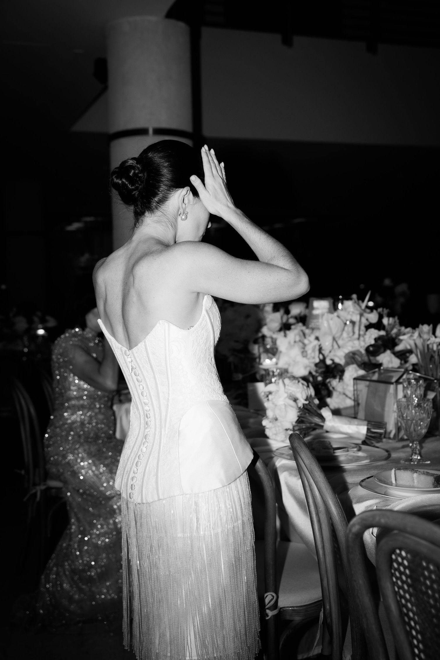 Wedding guests in white and sparkly dresses dancing together at an elegant reception celebration.