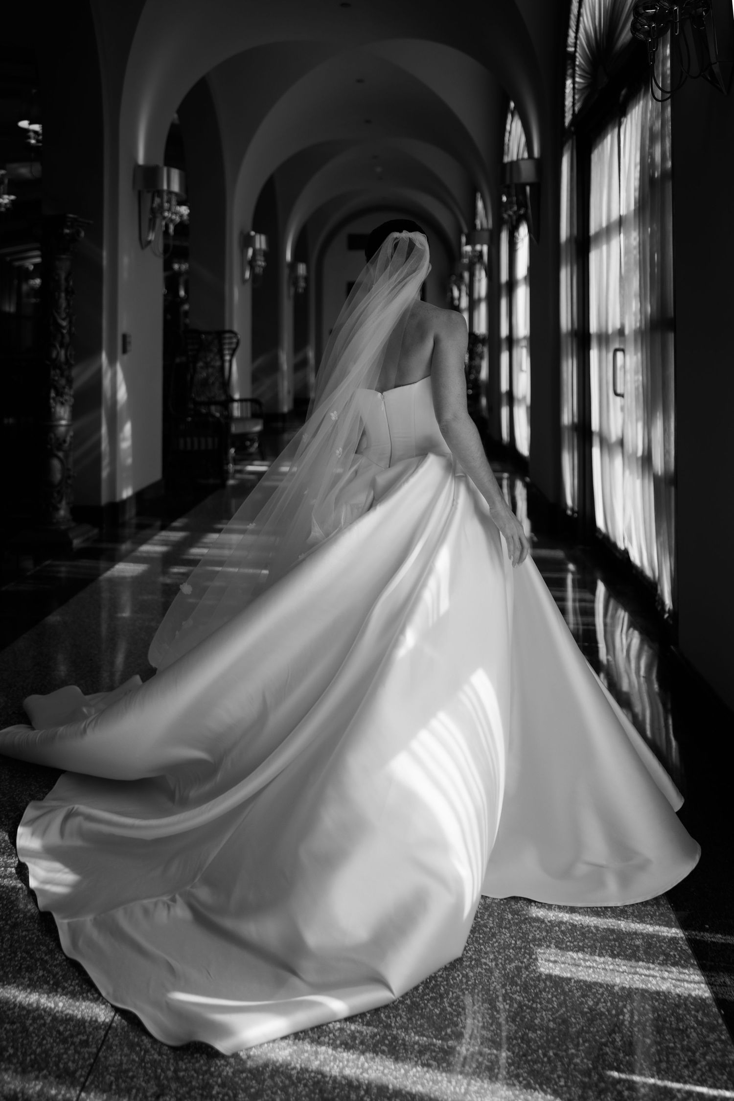 Dramatic black and white photos capturing a bride's dress swirling in an elegant hallway.