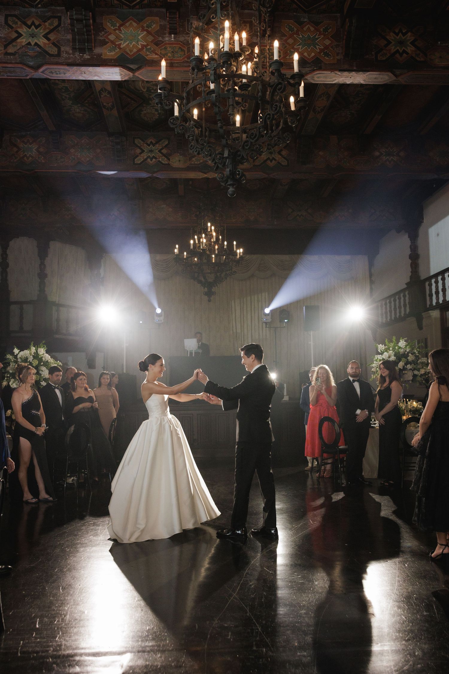Wedding reception dance floor with spotlights and chandeliers creating an atmospheric ambiance.
