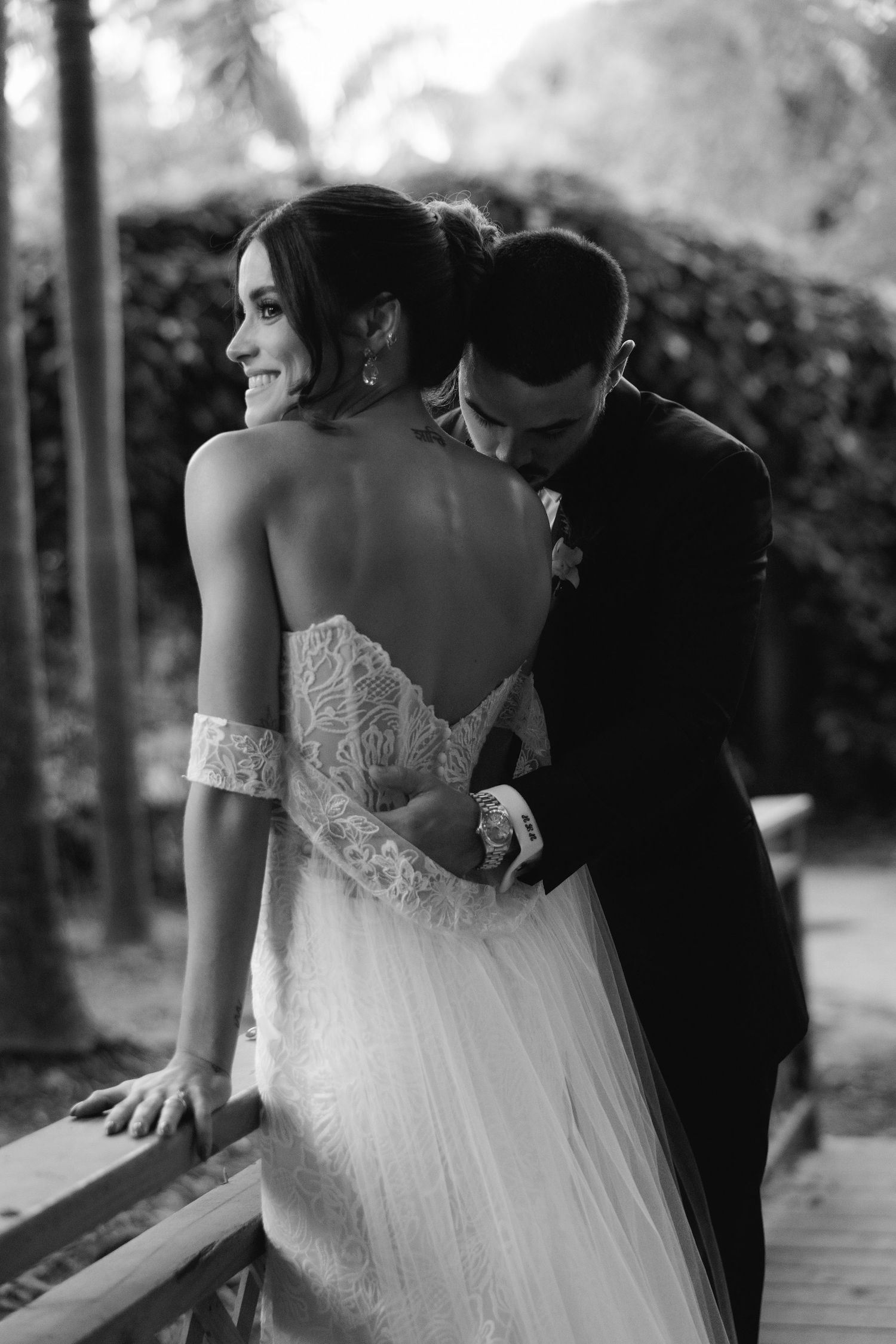 Intimate black and white wedding portraits captured on a rustic wooden deck.