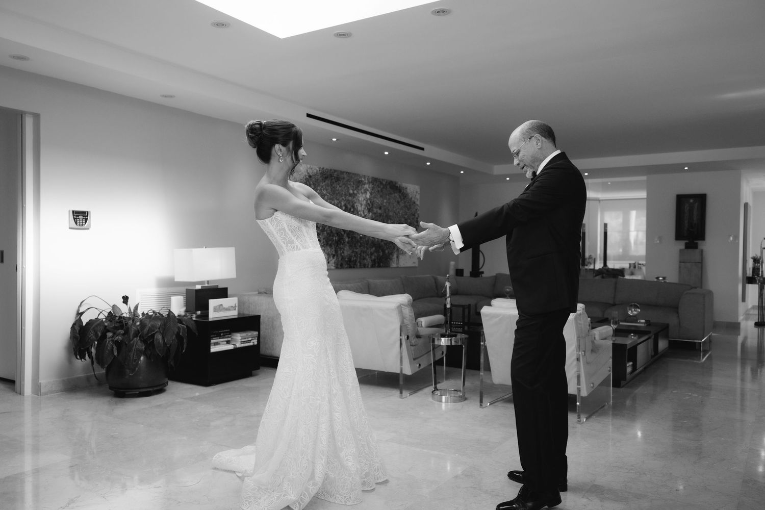 Black and white panoramic shot of wedding preparations in a modern indoor space.