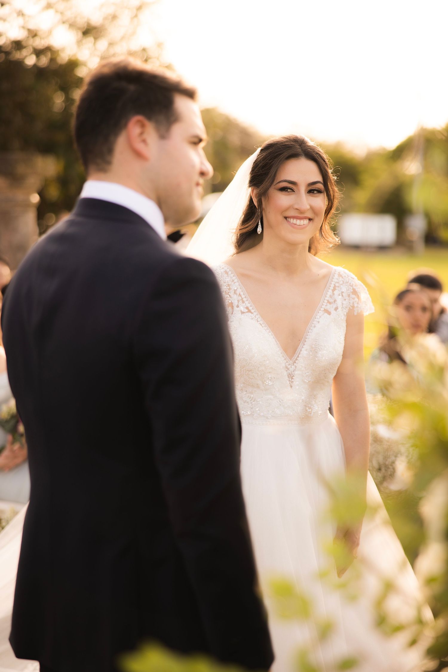 A couple shares intimate moments at sunset during their outdoor wedding celebration.
