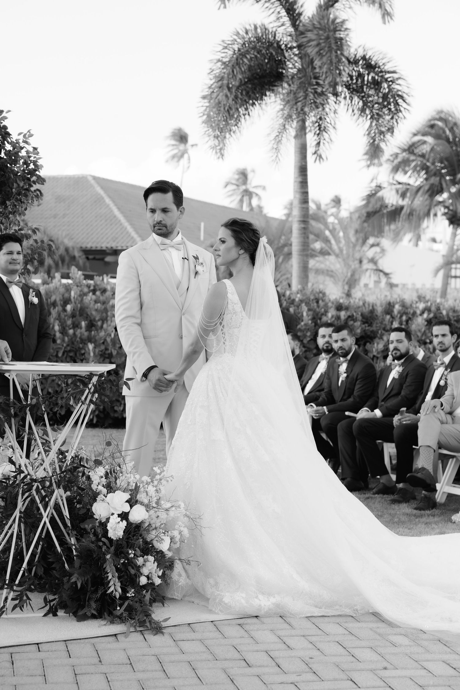 A sequence of black and white wedding photos showing a joyous couple dancing during their tropical destination wedding ceremony.