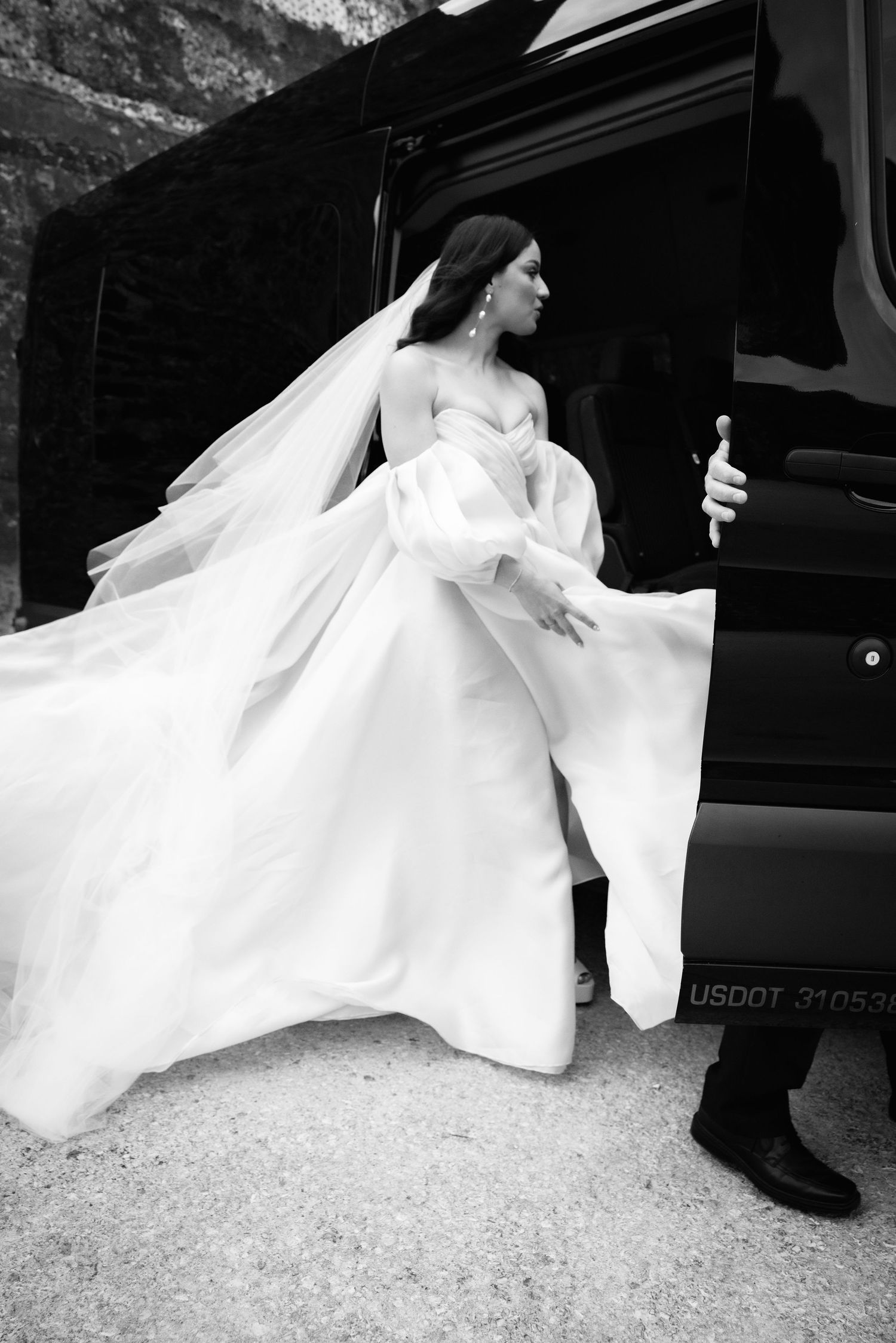 Dramatic black and white photos of a wedding dress flowing near a vehicle doorway.