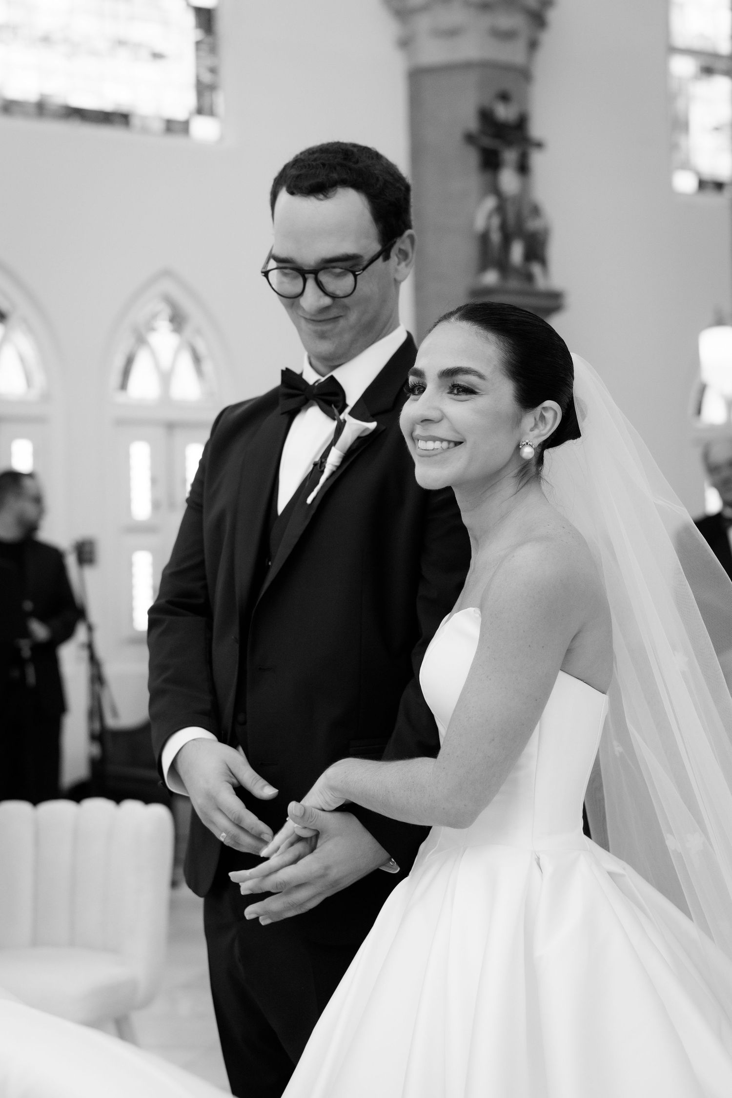 Candid moments captured during church wedding ceremony in black and white.