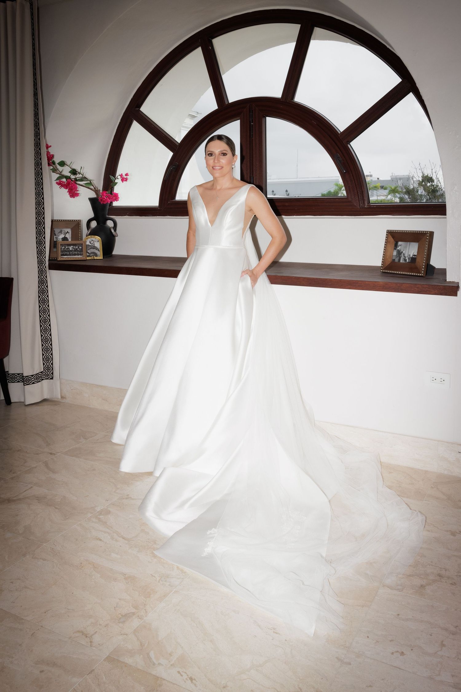Wedding gown with full skirt twirls on marble floor beneath arched windows in elegant bridal portrait series.
