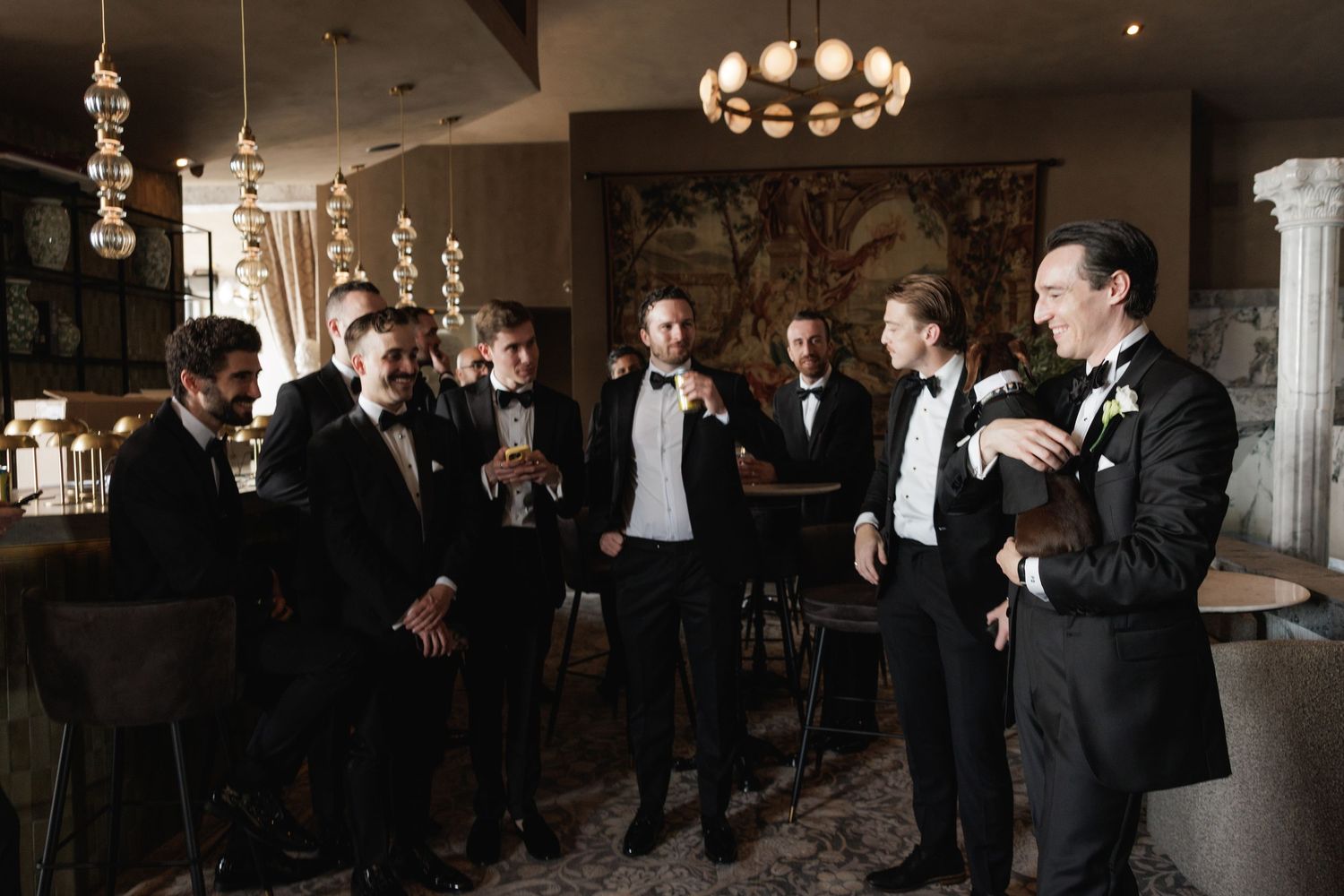 People mingle and socialize at an upscale indoor event with elegant lighting and formal attire.