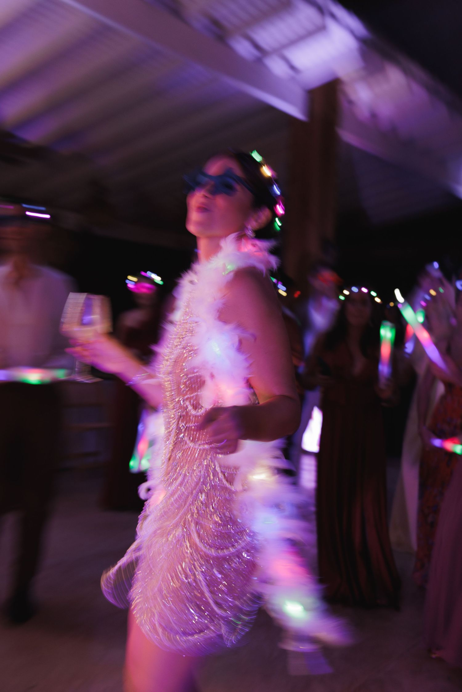 Motion-blurred dancers spinning under colorful disco lights creating a dreamy atmosphere.