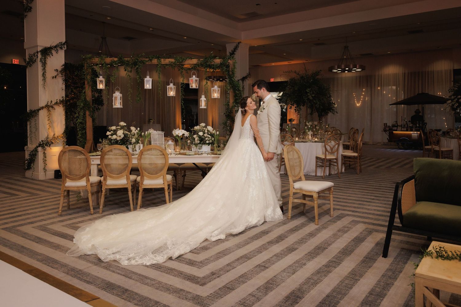 Elegant bride and groom share a romantic first look in an upscale hotel lobby with geometric pattern flooring.