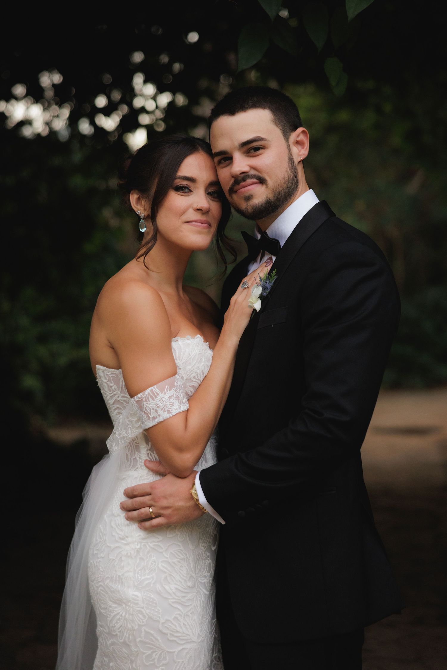 Romantic wedding portrait in natural lighting with bokeh background effects.