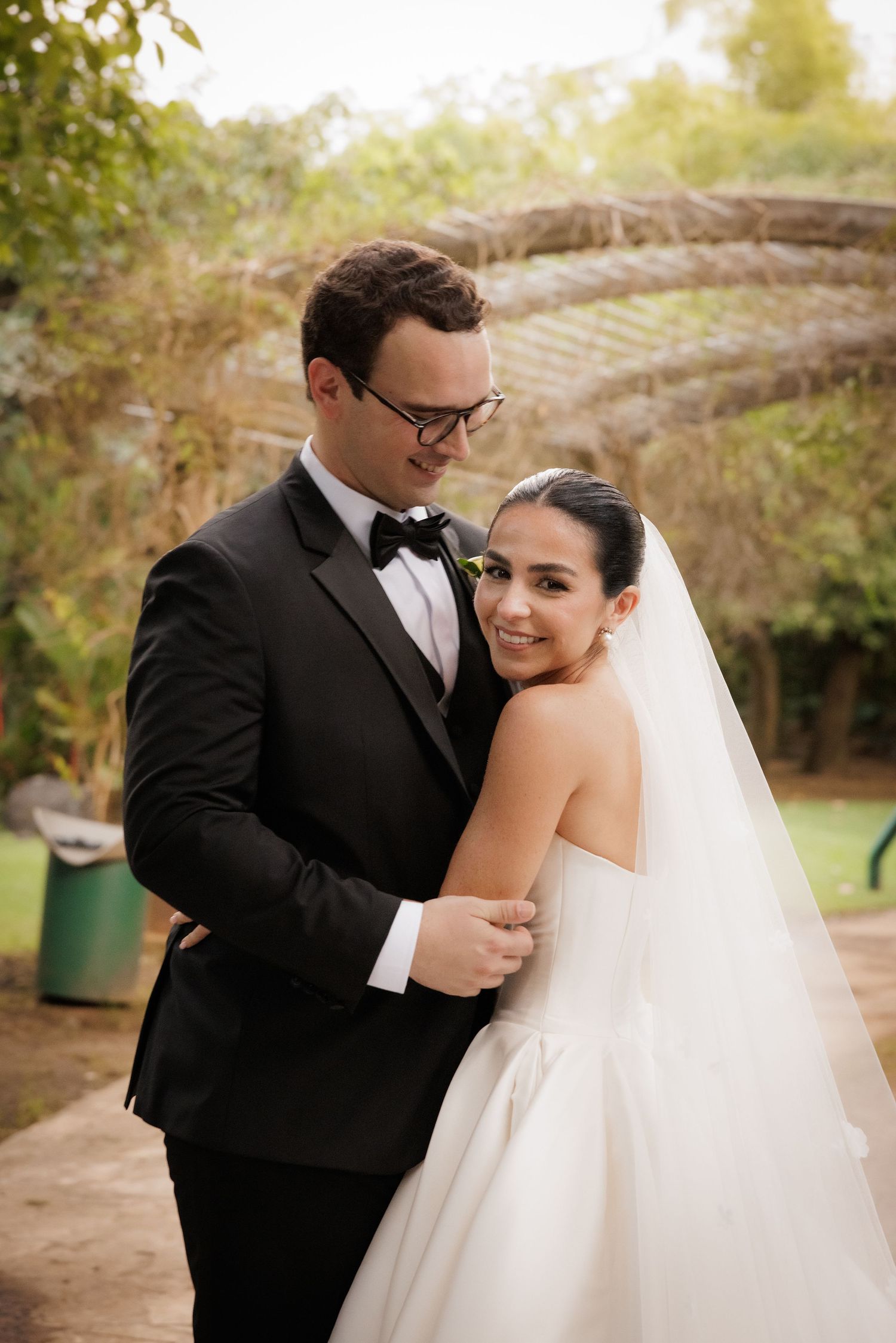 Romantic outdoor wedding portraits captured in a natural garden setting during golden hour.