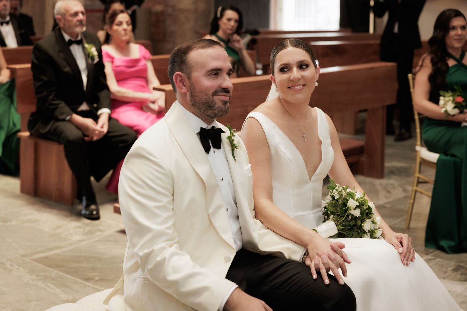 Wedding guests and couple celebrate during a reception in a church setting.