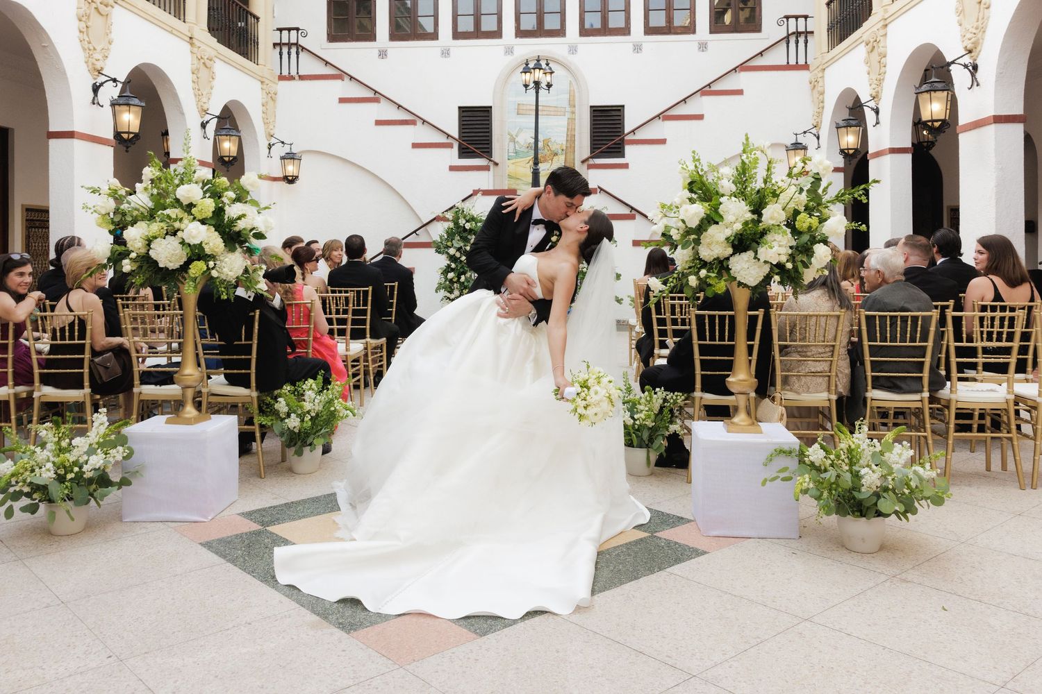 A series of elegant wedding photos showing floral arrangements and white decor in a grand indoor venue.