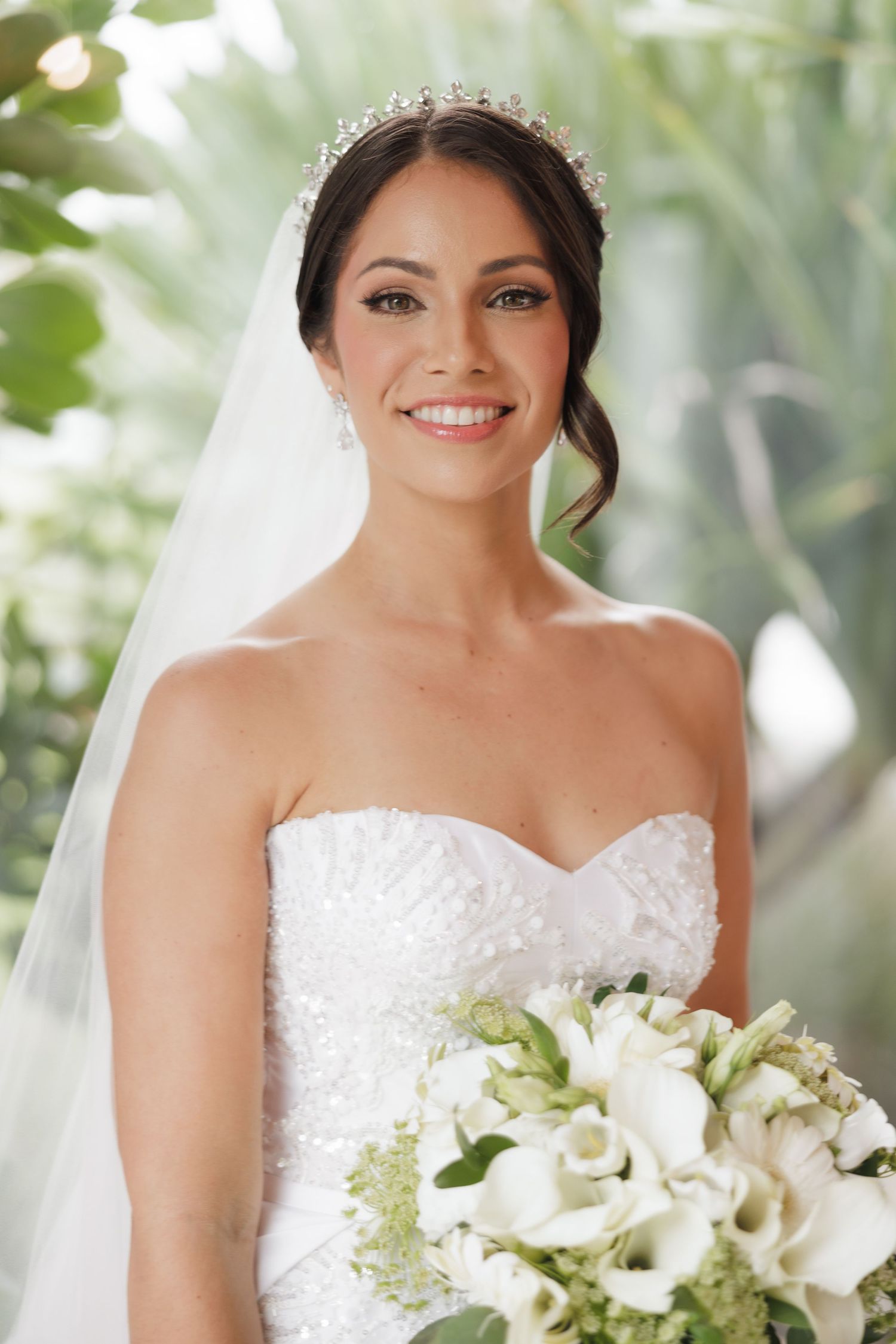 A bridal portrait featuring a white bouquet of calla lilies and delicate veil.