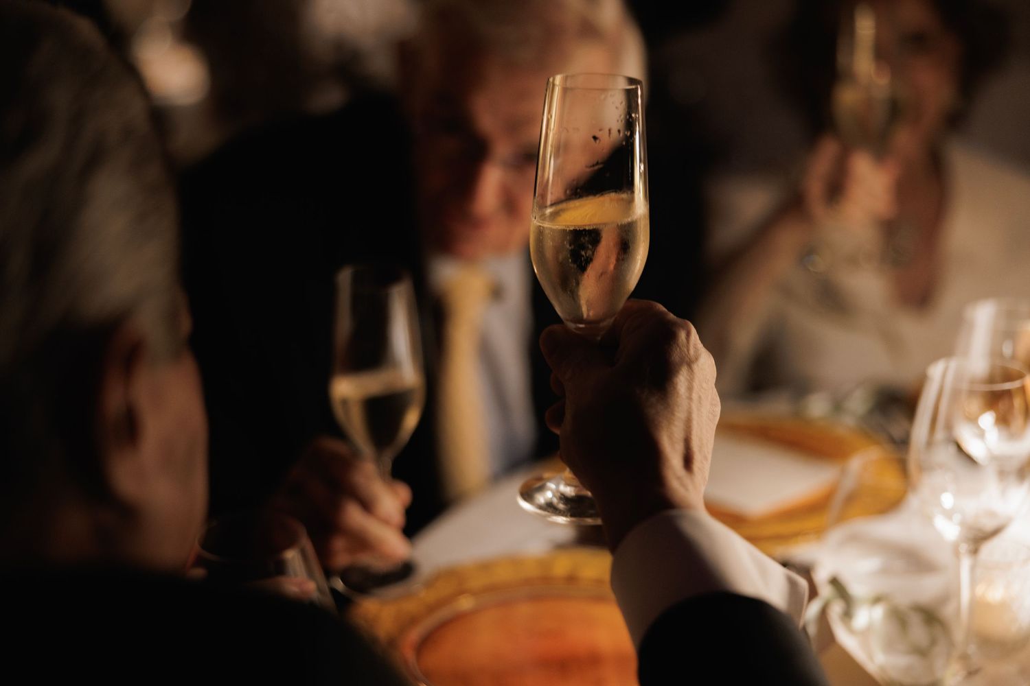 A sequence of elegant wine glasses in a dimly lit restaurant setting creates an atmospheric dining ambiance.