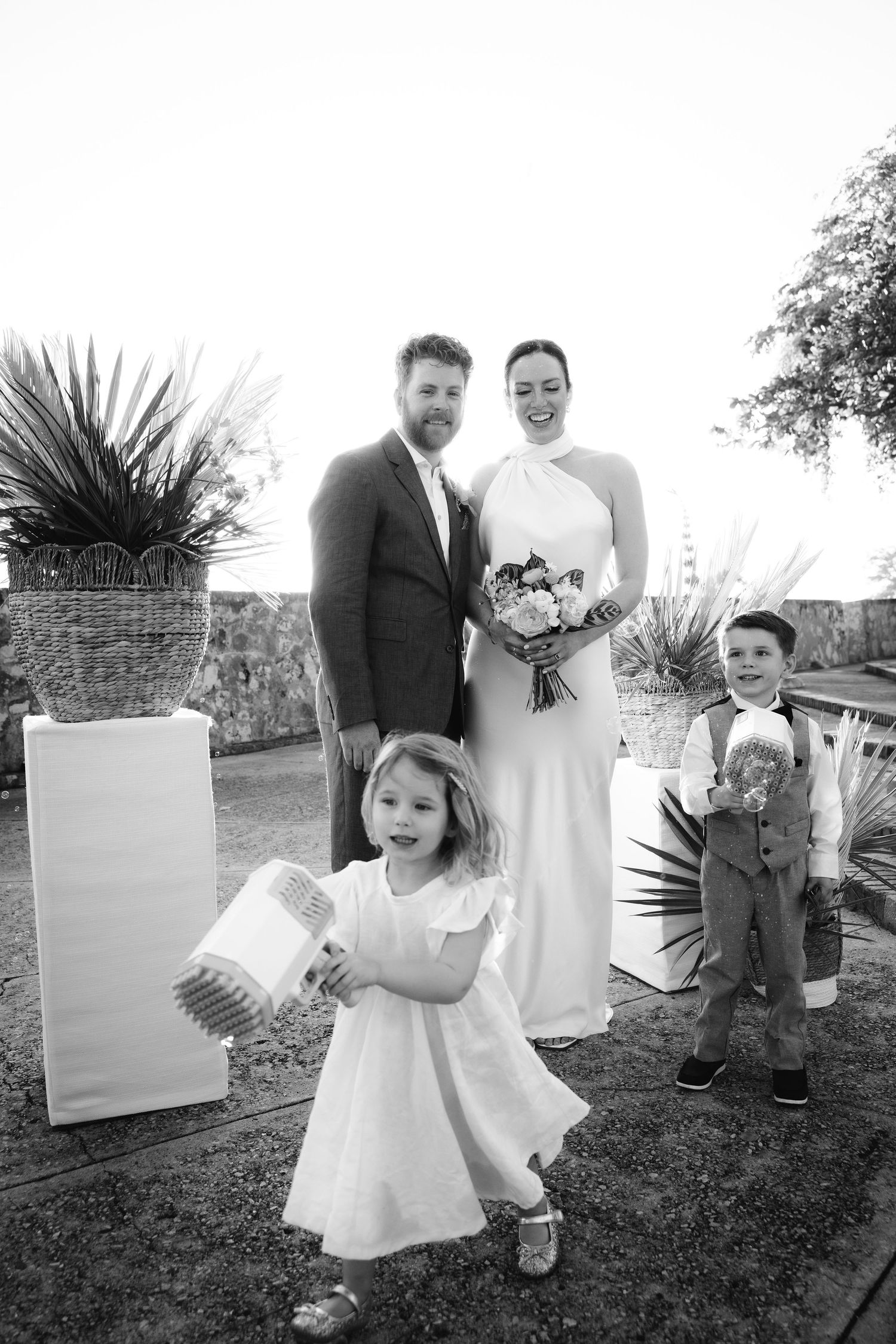 Black and white photos of wedding party members on garden grounds.