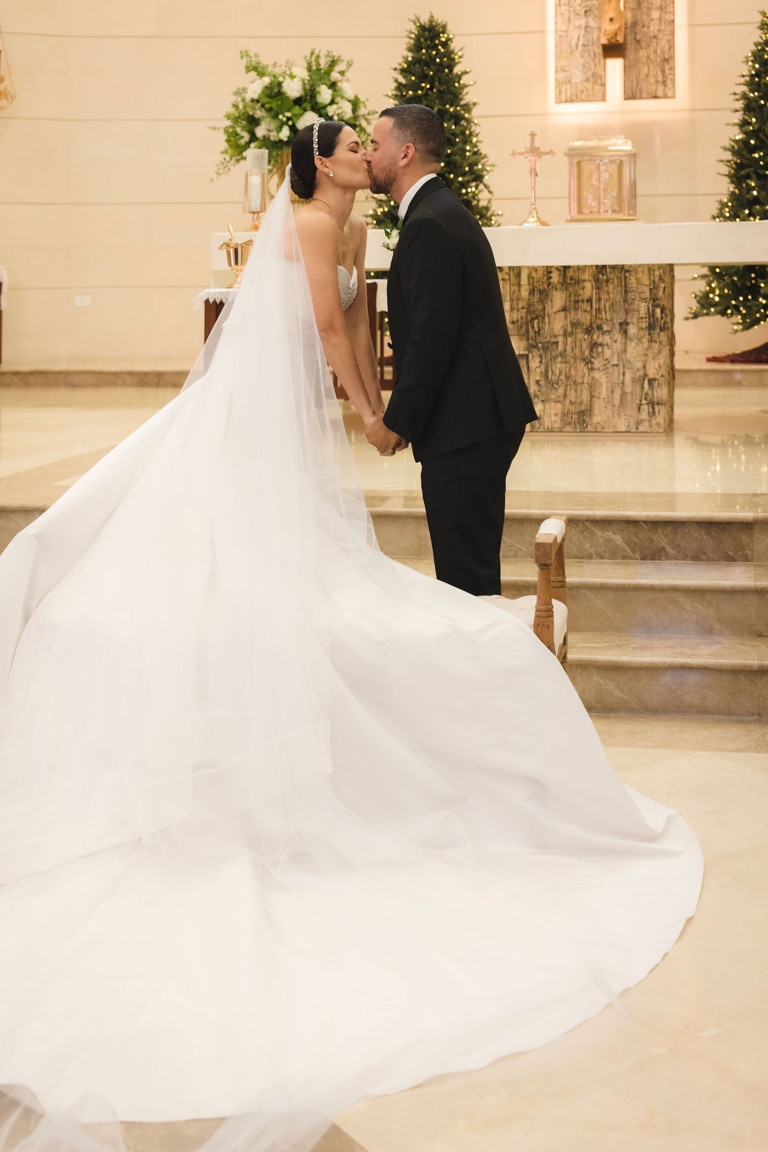 A romantic wedding moment captured in a church with flowing white dress and elegant decor.