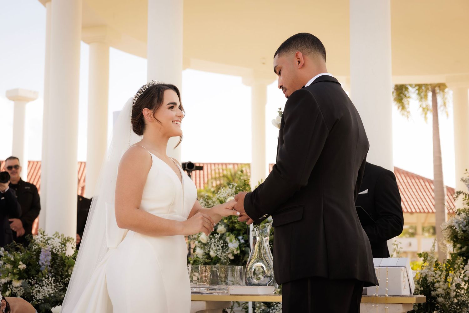 Wedding couple dancing together on a beautiful outdoor terrace at sunset.