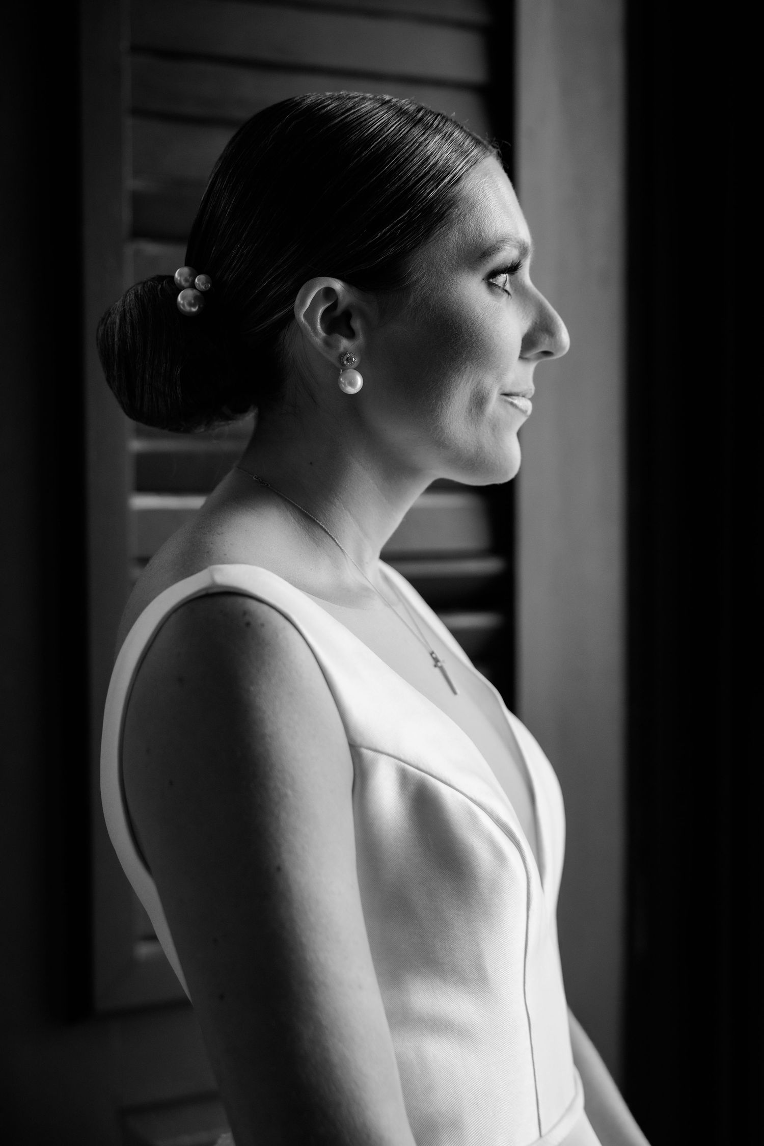 A series of black and white profile portraits showing a person in a white sleeveless dress with an elegant updo hairstyle.